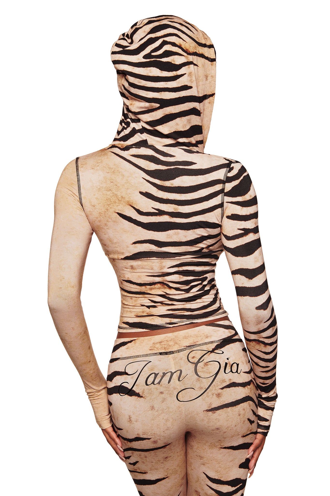 A person wears I.AM.GIA’s BLARE TRACKPANT in the Wild Side print, featuring tan and black tiger stripes, shown from the back with "I Am Gia" branding on the lower back for a bold statement.