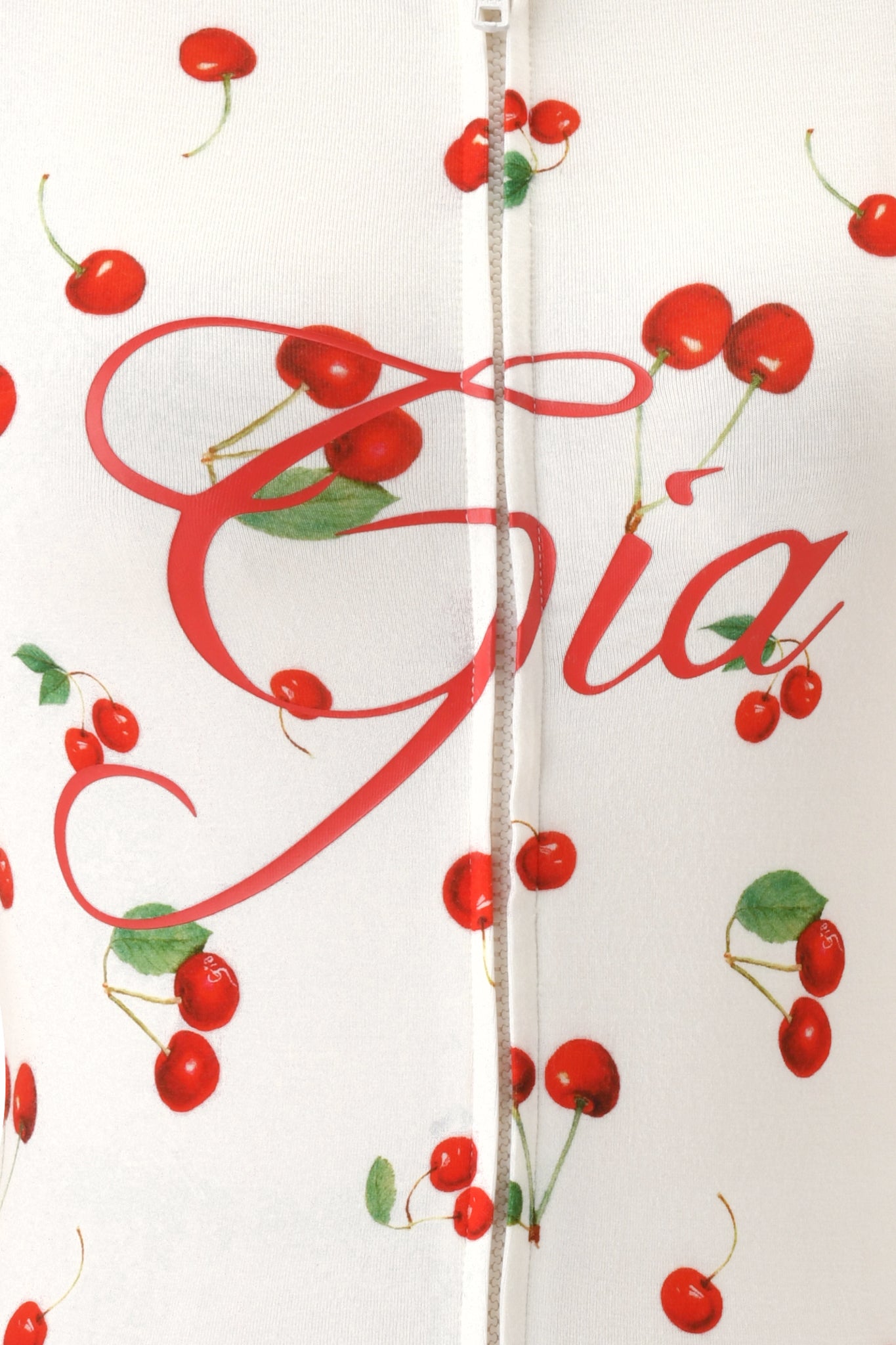 The BLARE HOODIE - CHERRY ON TOP by I.AM.GIA features a white fabric with red cherries, green leaves, and the cursive "Gia" print, plus a standout visible zipper seam across the center.