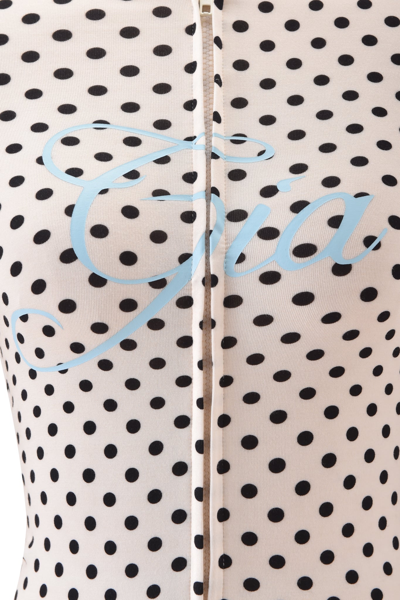 Close-up of the I.AM.GIA BLARE HOODIE in cream polka dot, featuring black spots, a vertical zipper, and "Gia" in large light blue cursive across the fabric.
