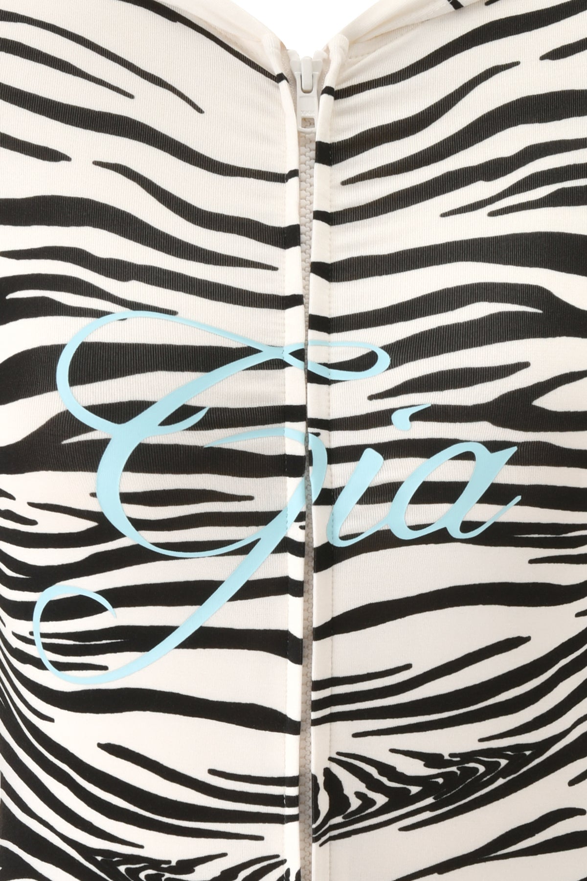 A close-up of the I.AM.GIA BLARE HOODIE - FINE LINE ZEBRA shows its bold zebra-print fabric, a zipper, and “Gia” in light blue cursive across the chest.