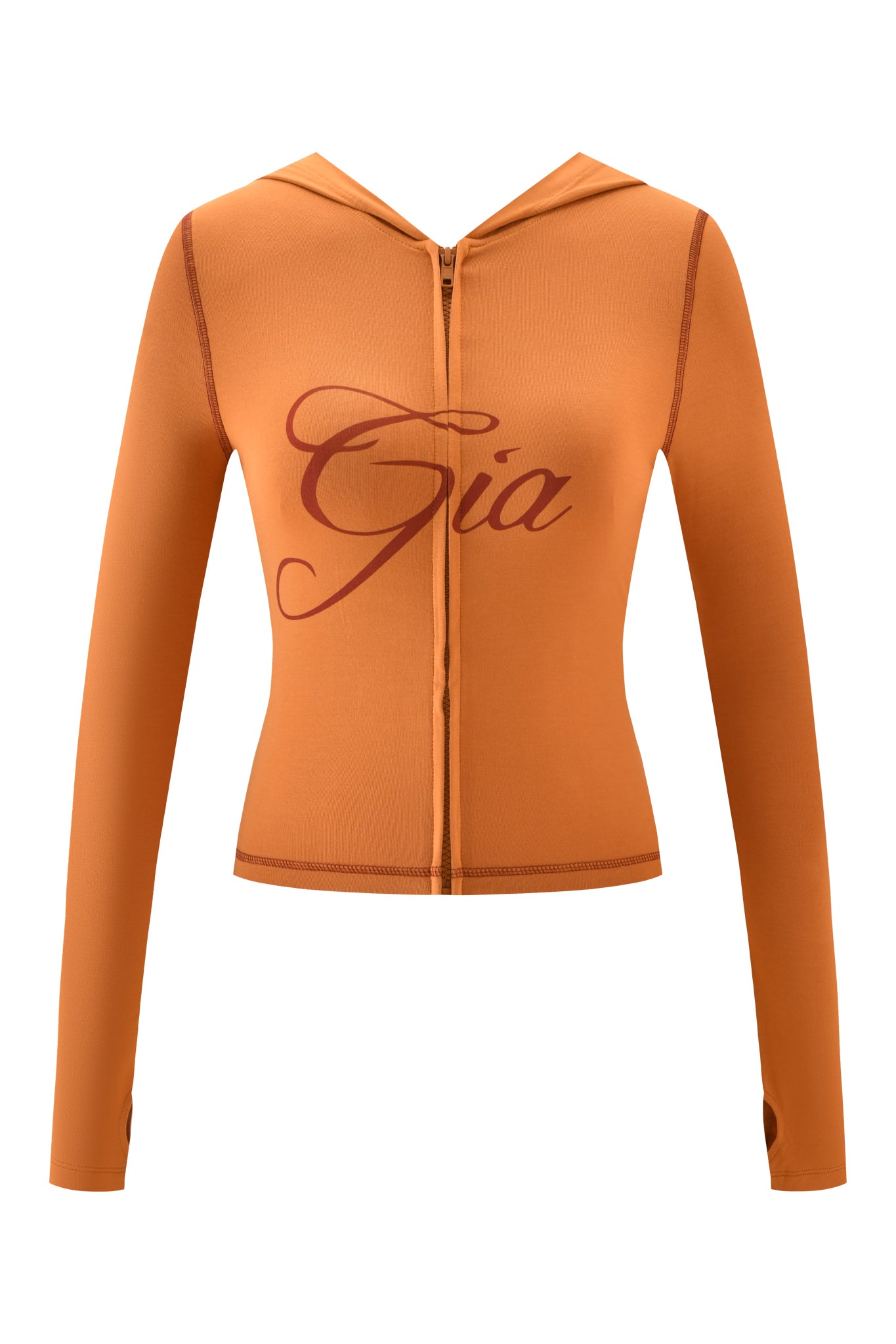 The BLARE HOODIE - PUMPKIN by I.AM.GIA is a fitted, long-sleeve zip-up hoodie featuring thumb holes and "Gia" in cursive on the chest.