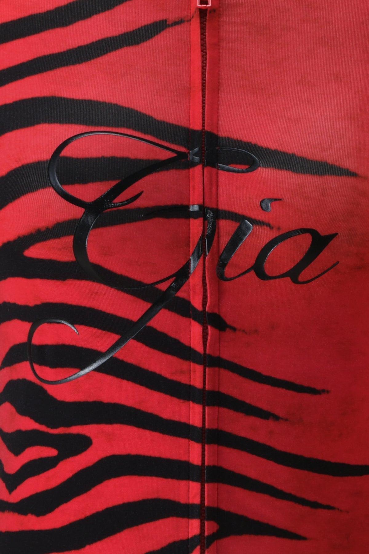 Close-up of the BLARE HOODIE by I.AM.GIA, featuring the signature Red Wild Side print—a bold red fabric adorned with black tiger stripes—crafted from soft bamboo material and finished with “Gia” elegantly scripted in black across the center.