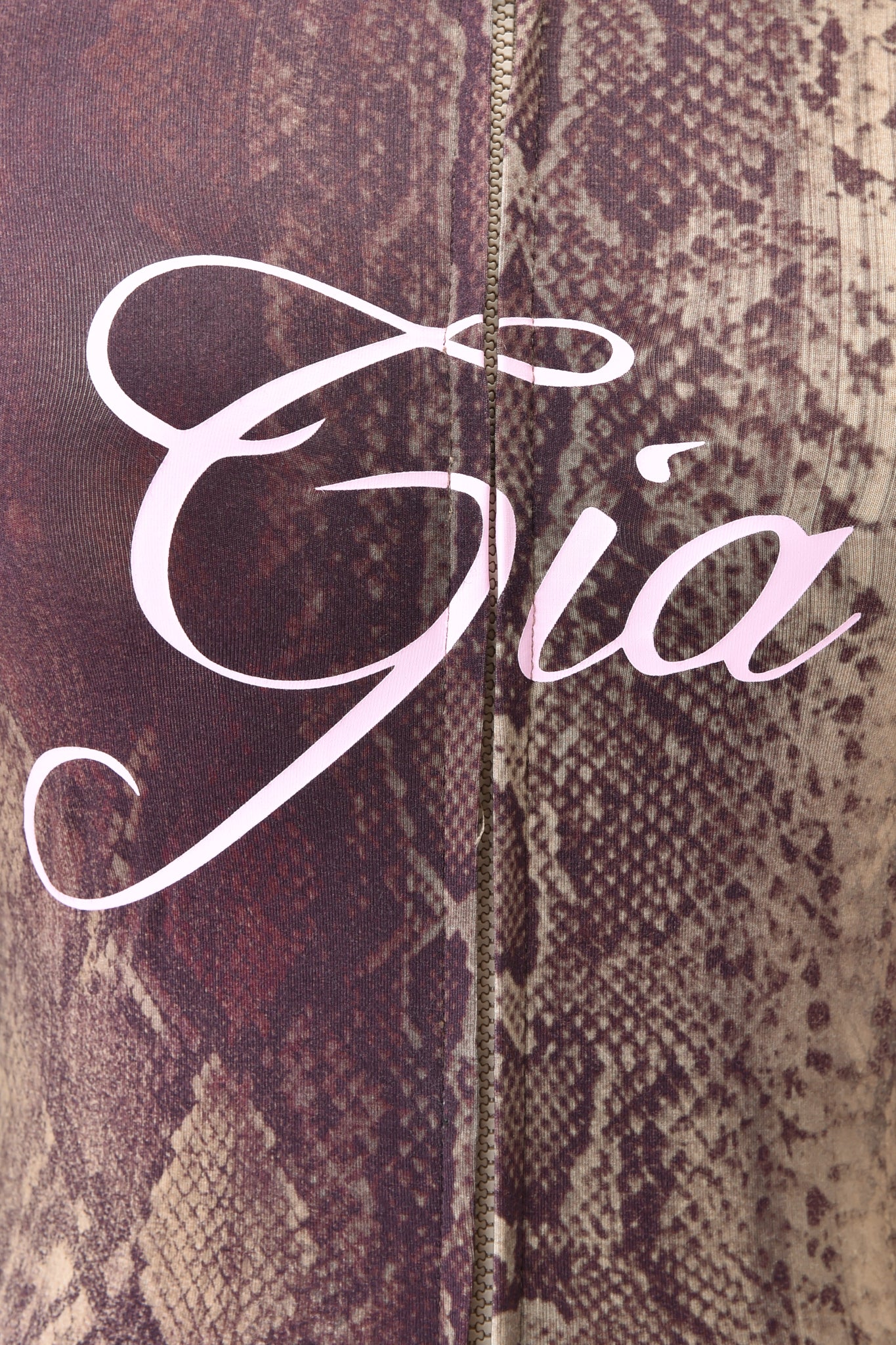 Close-up of the BLARE HOODIE - SNAKE by I.AM.GIA in brown and tan snake print, featuring "Gia" in large pale pink cursive and a vertical center seam for added style.