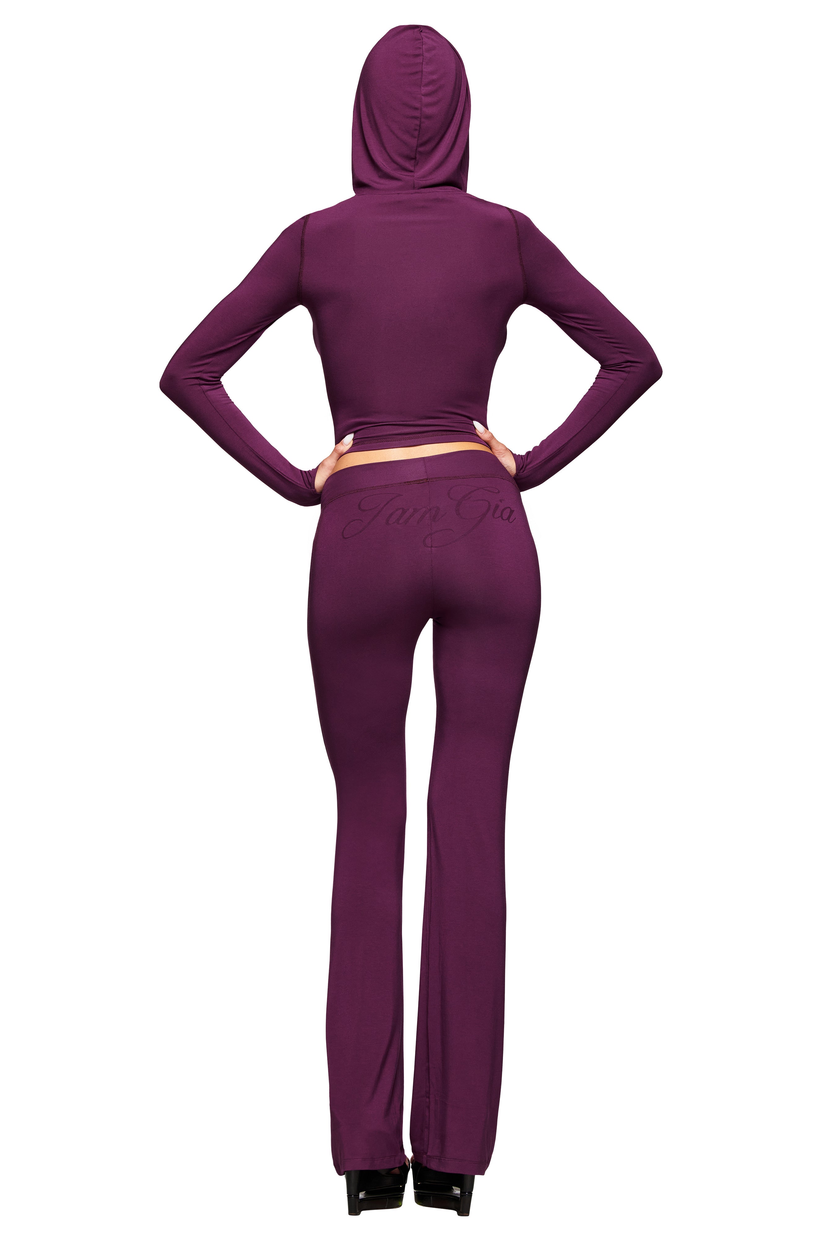 A woman wears the I.AM.GIA BLARE TRACKPANT in plum, featuring a low-rise waist.