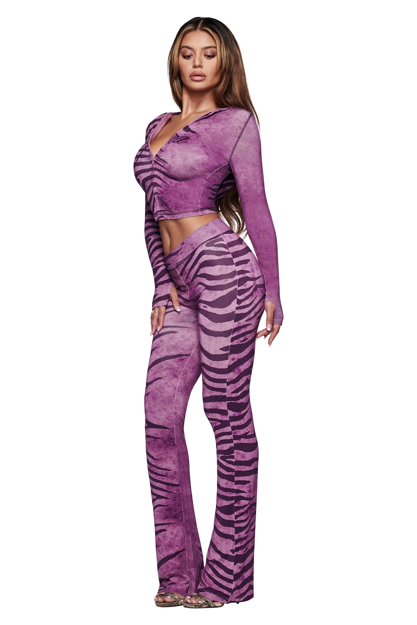 A woman poses in the I.AM.GIA BLARE HOODIE in the Plum Wild Side print against a white background.