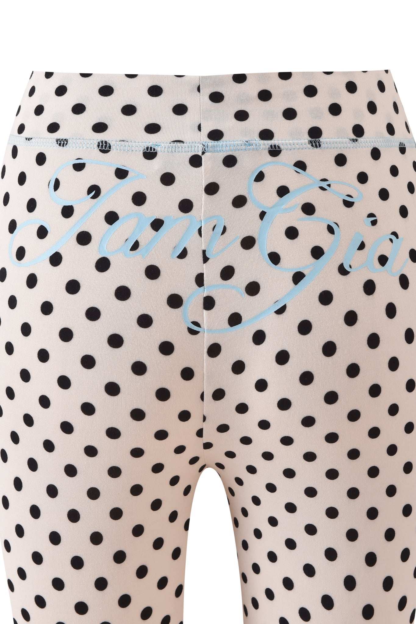 Close-up of the BLARE TRACKPANT - CREAM POLKA DOT by I.AM.GIA, featuring a white polka dot design and blue cursive "I.AM.GIA" text on the back waistband.