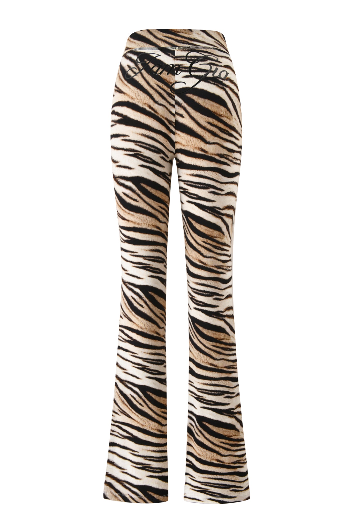 The BLARE TRACKPANT - LIGHT TIGRESS by I.AM.GIA is a high-waisted, flared pant featuring a black, brown, and white tiger stripe pattern with black cursive text on the waistband for a bold statement look.