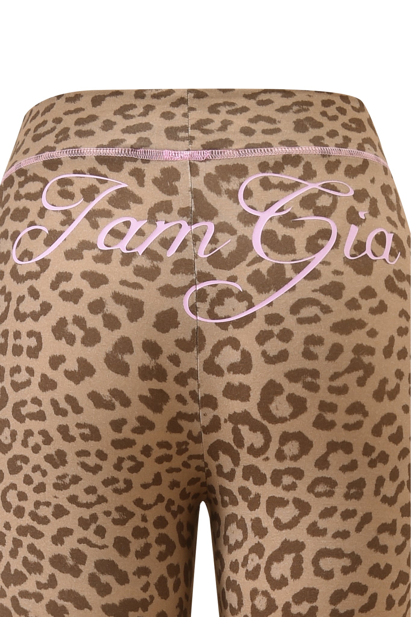 Close-up of the BLARE TRACKPANT - MOCHA LEOPARD by I.AM.GIA, showing "I Am Gia" in bold pink cursive across the waistband and upper back.