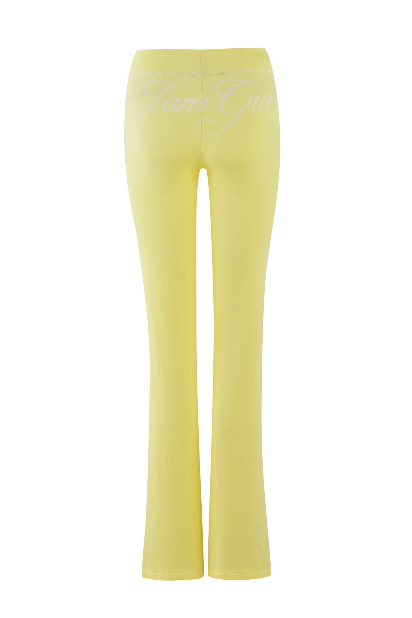The BLARE TRACKPANT in pale yellow by I.AM.GIA features a high-waisted flared design, crafted from bamboo and jersey material. The brand's logo is elegantly scripted in white across the back, set against a pristine white background.