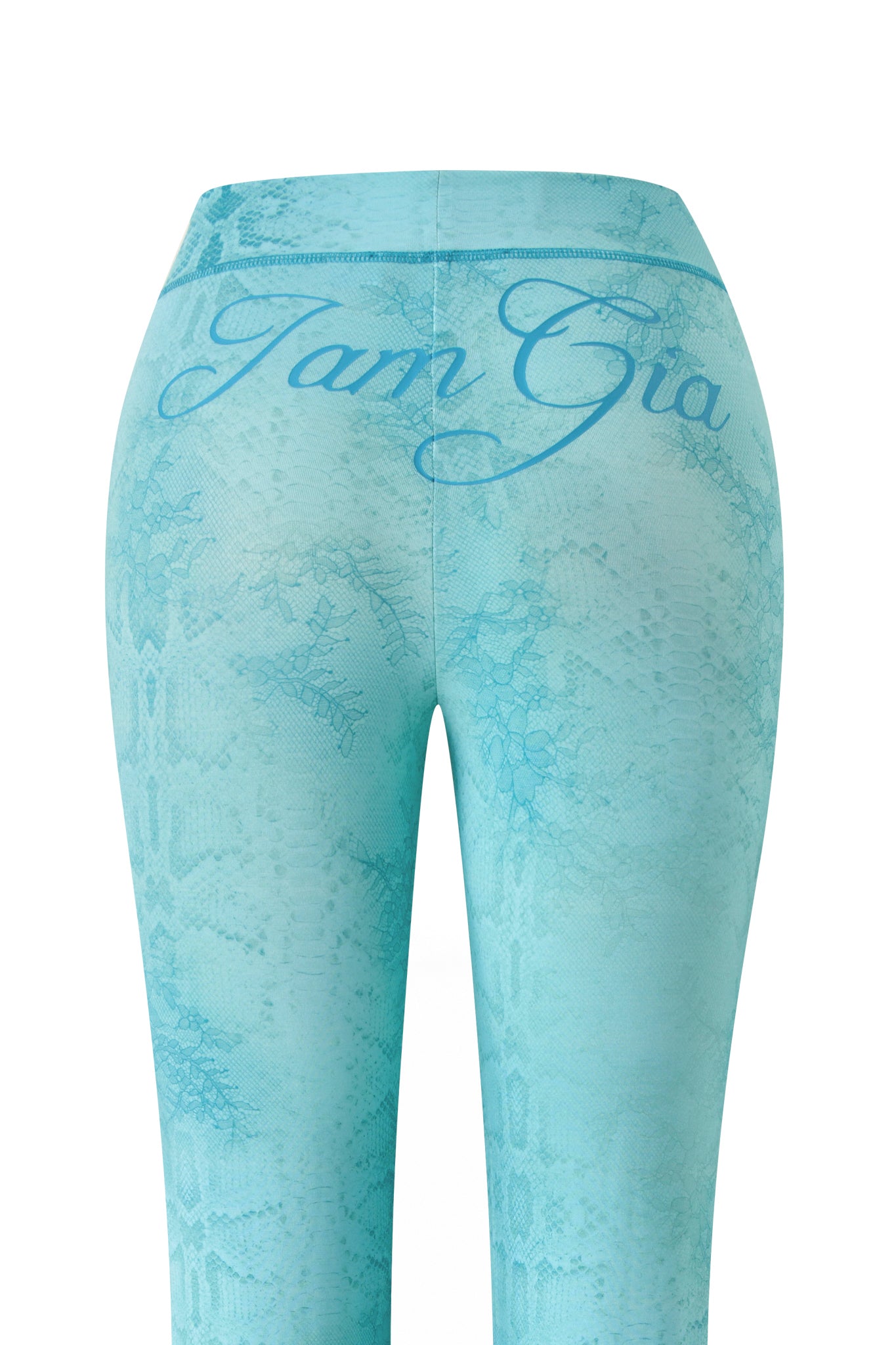 The image shows the back view of I.AM.GIA BLARE TRACKPANT - TEAL SERPENTINE leggings, featuring a subtle snakeskin pattern and large cursive "I.AM.GIA" lettering across the waistband.