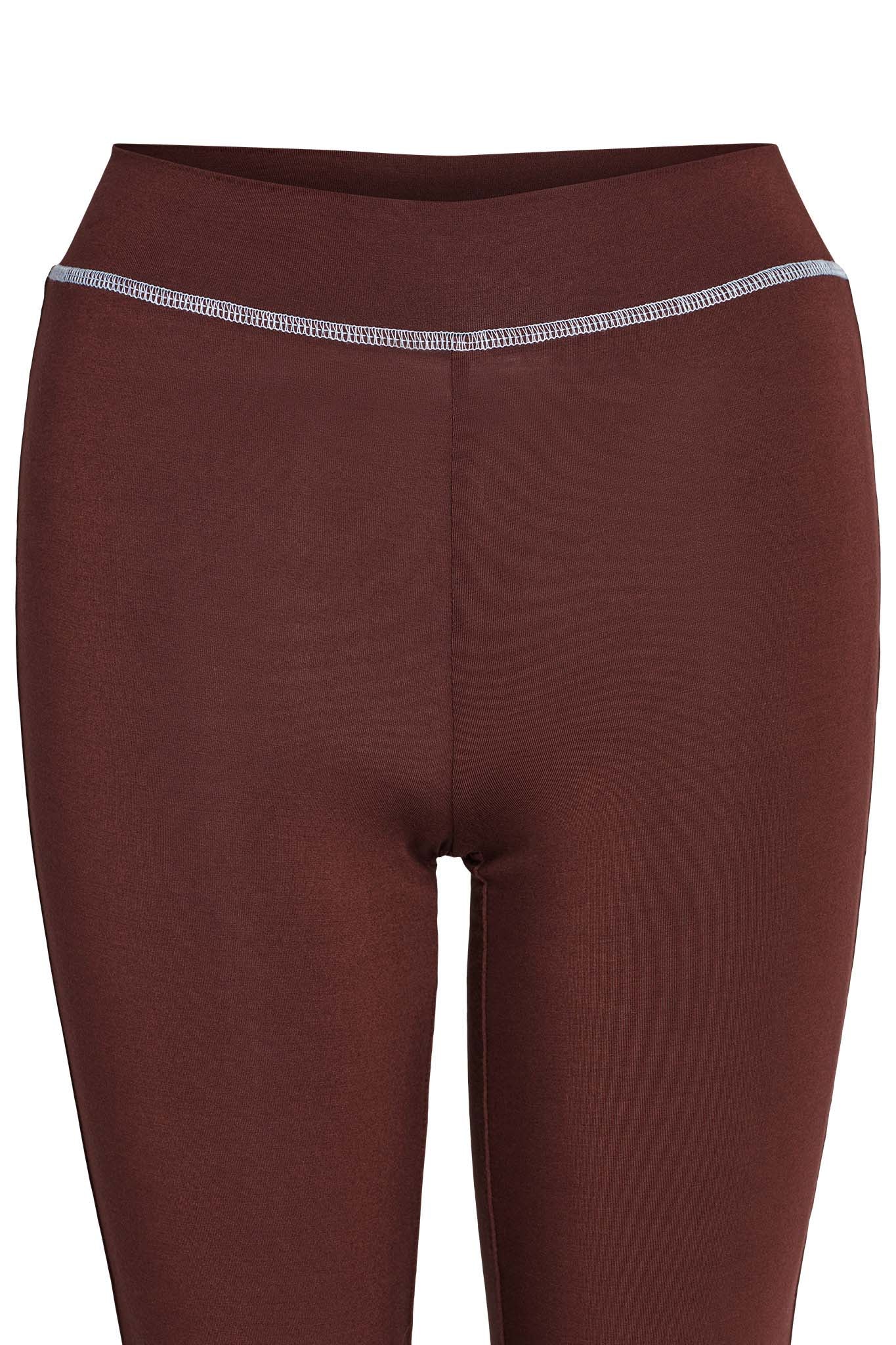 A close-up of the BLARE TRACKPANT - BROWN from I.AM.GIA featuring a seamless design with a wide waistband. The trackpants have a light gray stitch detail along the top edge of the waistband, providing a subtle contrast. The fabric appears smooth and stretchy.