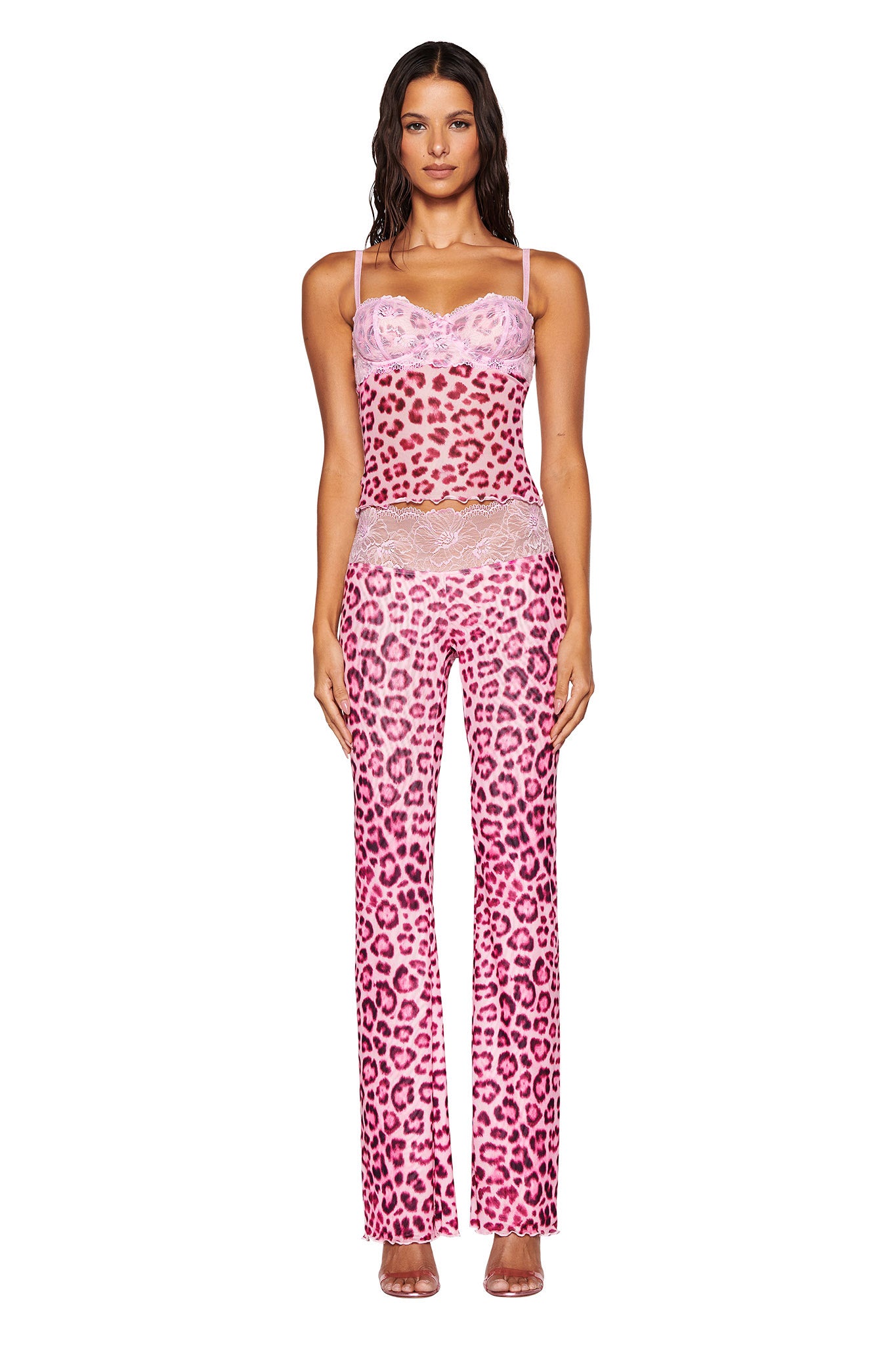 A woman is confidently standing against a plain white background, wearing the SILO TOP in pink leopard print by I.AM.GIA, complete with a lace-trimmed camisole and matching mesh fabrication pants.