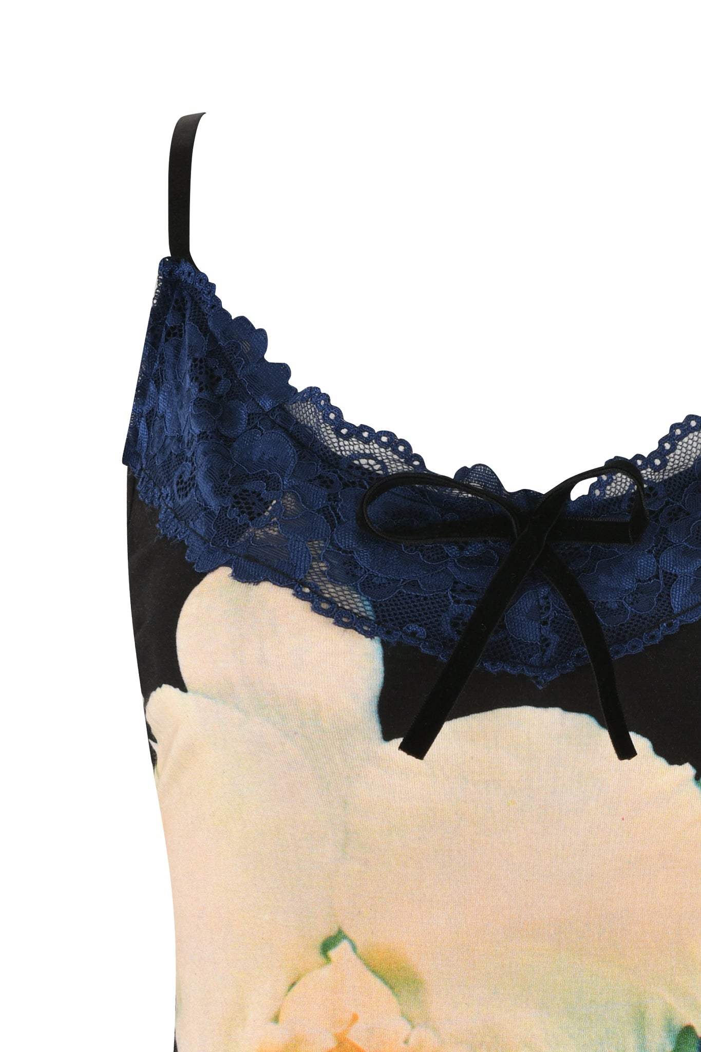 Close-up of the ADELLA TOP - BLACK : FLORAL : BLACK ORCHID by I.AM.GIA, showcasing a custom graphic floral print in cream and light pink hues. The Cami top features blue lace trim and black ribbon detail at the neckline. An adjustable black strap is visible on the left side of the image.