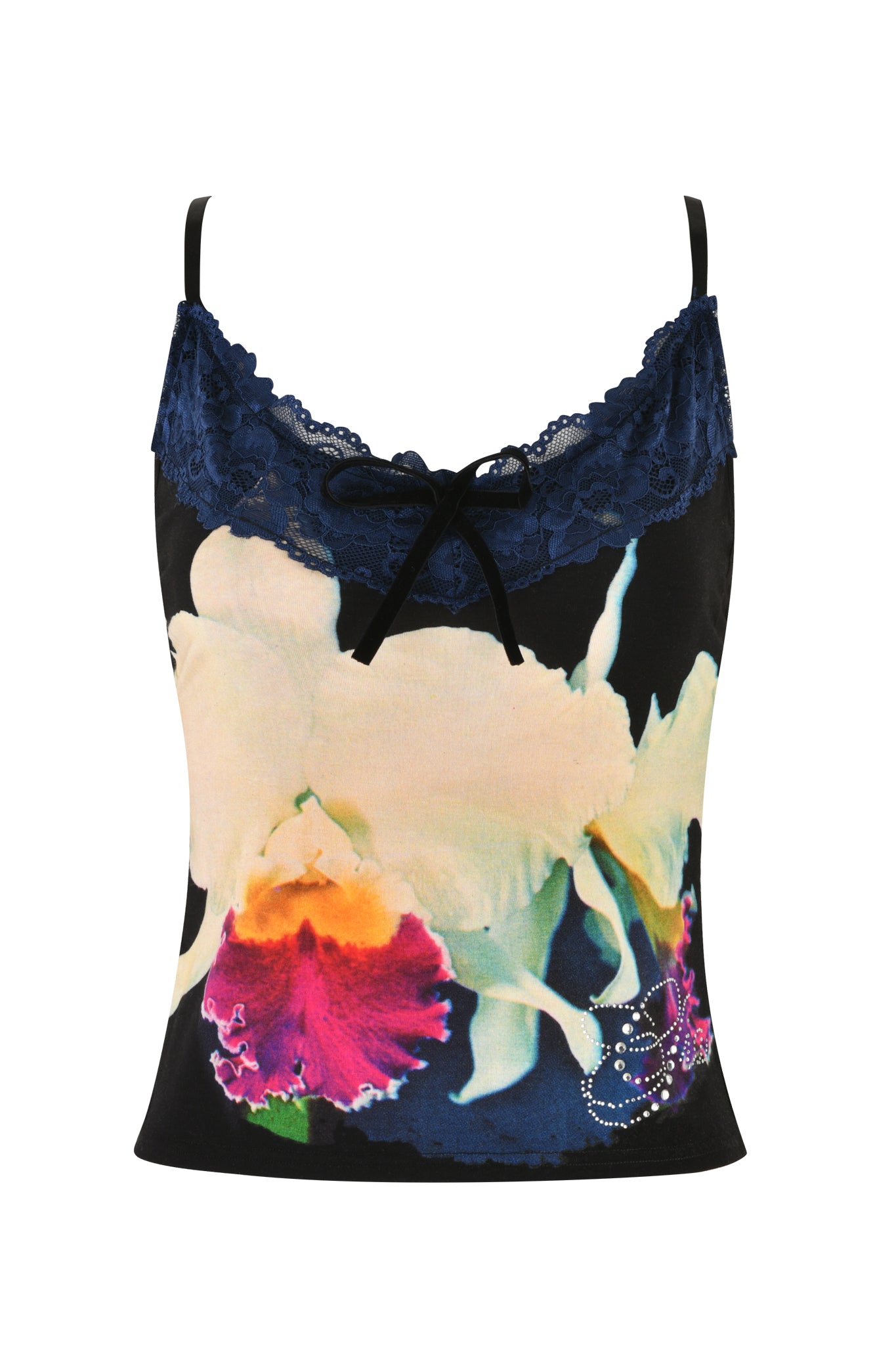 The ADELLA TOP - BLACK : FLORAL : BLACK ORCHID by I.AM.GIA features a vivid, custom graphic floral print of large orchids on a black cami top. The top edge is accentuated with dark blue lace and adorned with a small black bow at the center. The orchid petals are white with pink and yellow highlights, and rhinestones embellish the bottom right.