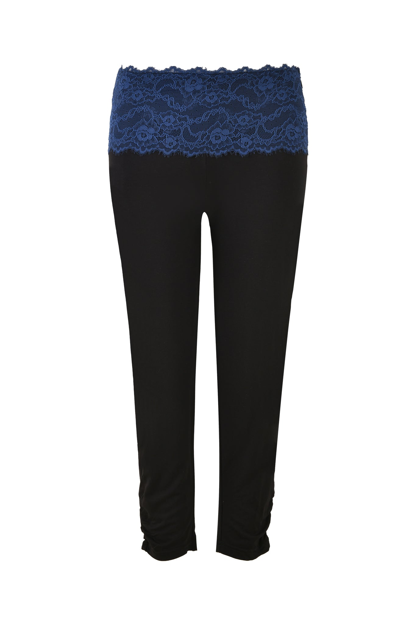 The ADELLA CAPRI - BLACK : FLORAL : BLACK ORCHID from I.AM.GIA features black capri pants adorned with a blue lace waistband and ruched detailing at the ankles. The bodycon silhouette enhances natural curves, while the lace adds an elegant touch to the minimalist design.
