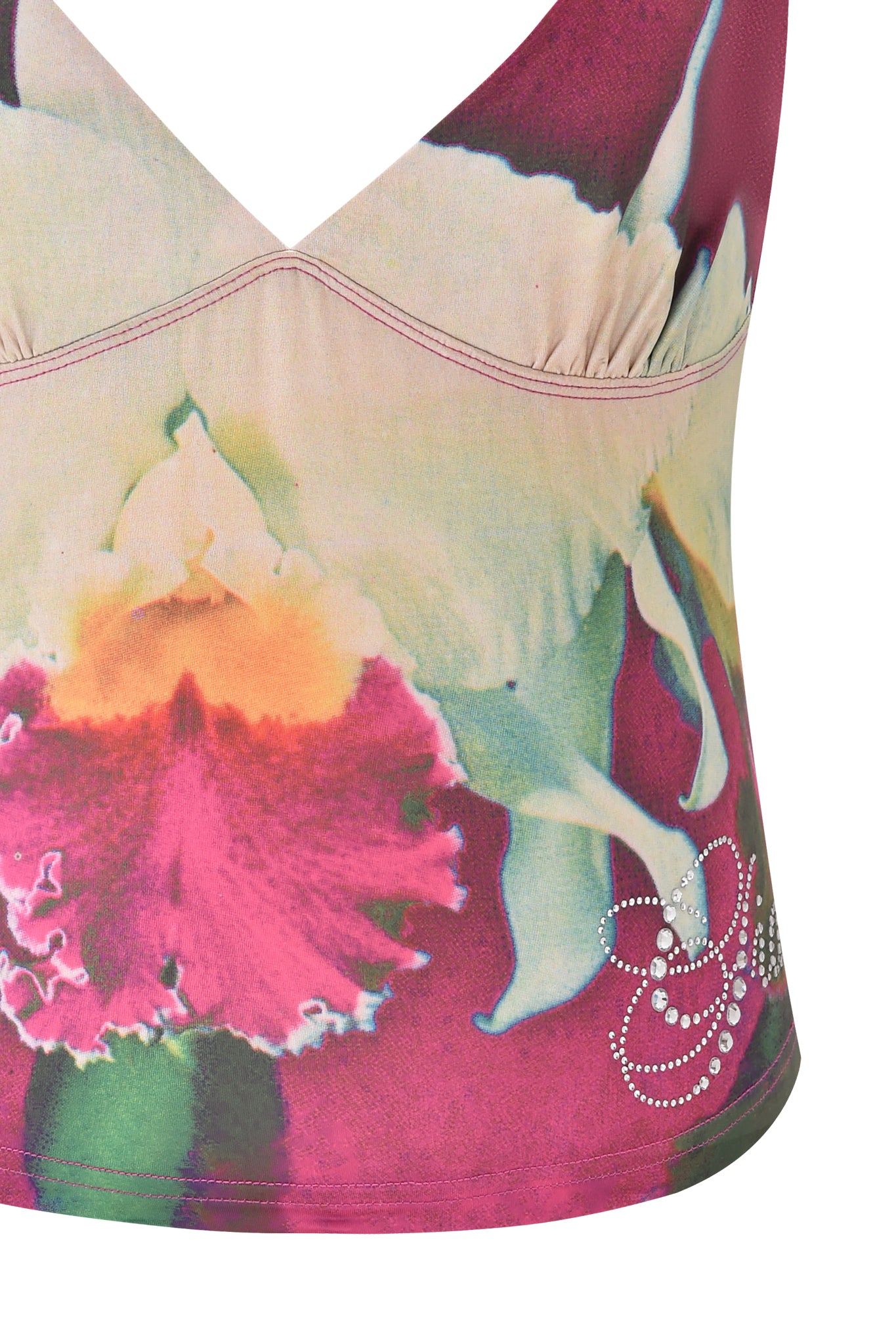 A close-up of the ODETTA TOP - FUCHSIA by I.AM.GIA, a sleeveless, bodycon top with a vibrant floral print in pink, white, yellow, and green shades and a rhinestone swirl embellishment near the bottom right.
