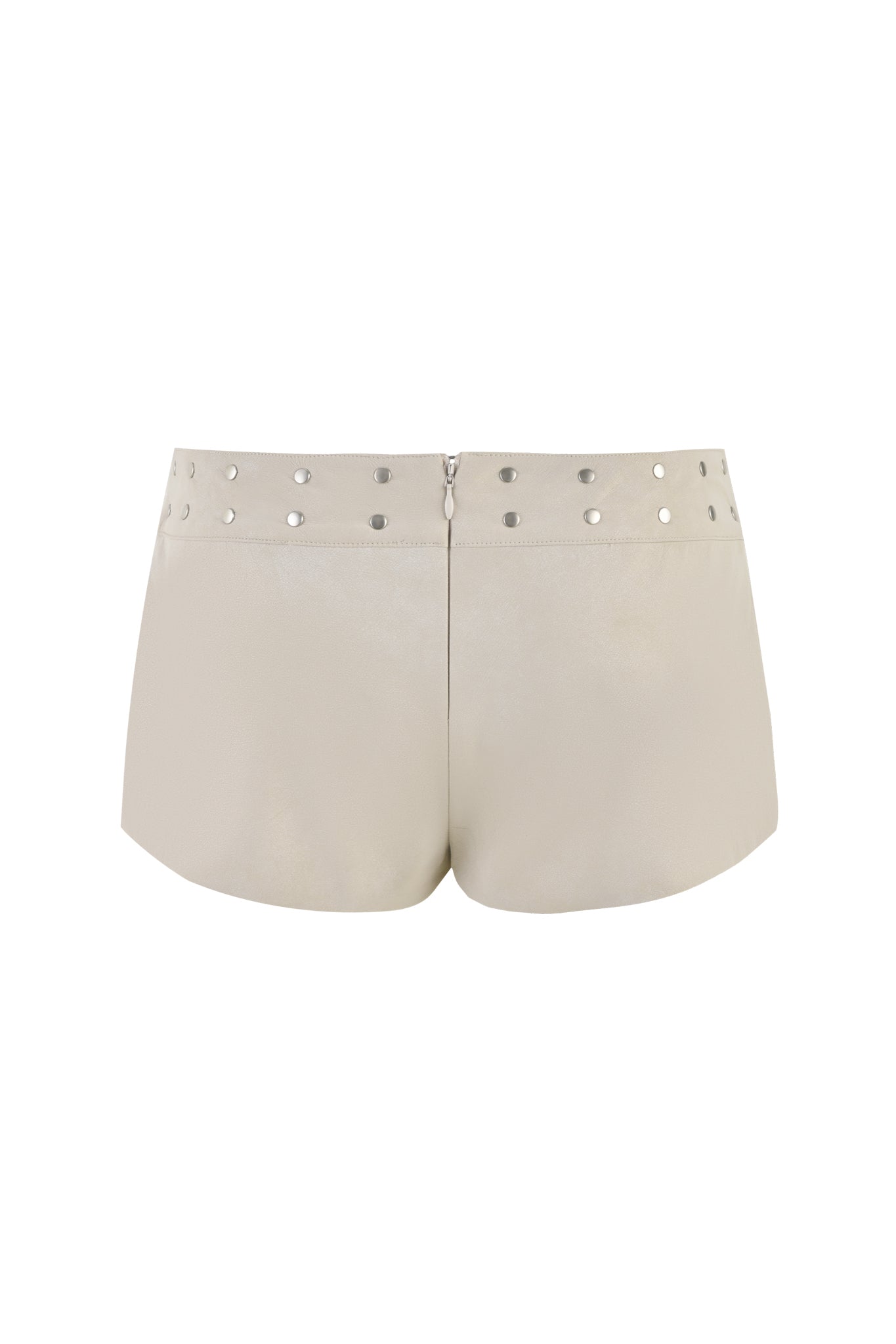 A back view of the I.AM.GIA DOLLY SHORT - NEUTRAL : TAN, featuring glossy cream faux leather fabric. The low-rise waist is adorned with evenly spaced silver circular studs and has a zipper closure at the back.