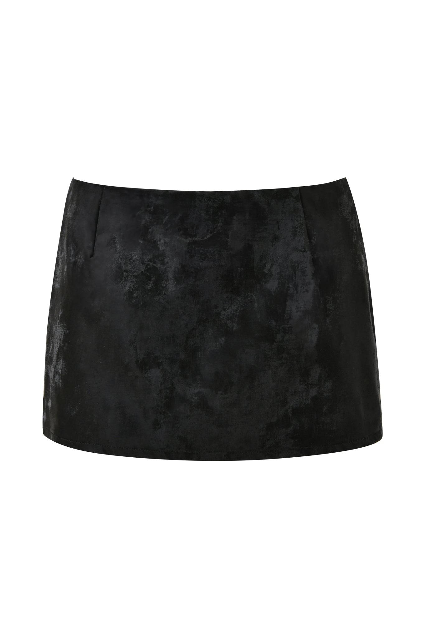 A close-up of the FRANCINE SKORT - BLACK by I.AM.GIA reveals its black suede fabric with a textured, slightly distressed look. The skort, featuring a bodycon fit, boasts a simple design free from visible patterns or embellishments. The image focuses on the lower half, highlighting the material and fit of this stylish piece.