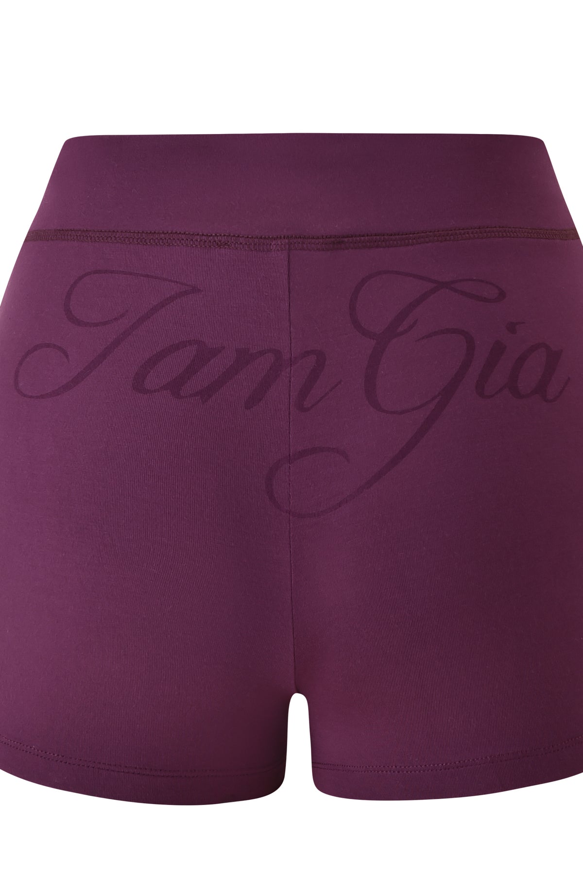 The BLARE SHORT - PLUM by I.AM.GIA are high-waisted, bodycon mini shorts featuring an elastic waistband and “I.AM.GIA” in large, cursive lettering across the back.