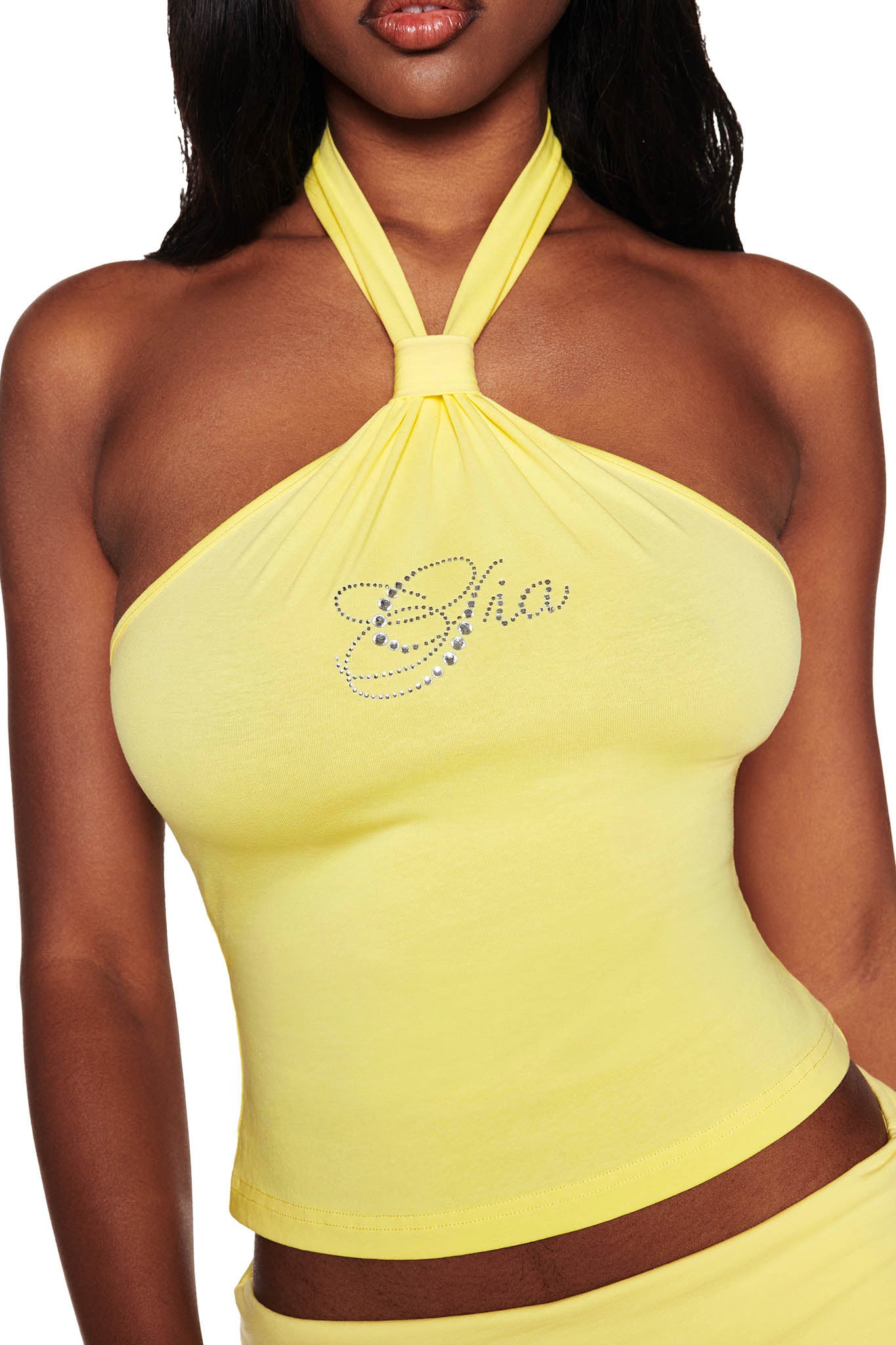A person in the I.AM.GIA ROWAN TOP - YELLOW, featuring a scripted chest design and diamanté logo, shown from shoulders to waist. The soft bamboo fabric fits well against the plain white background.