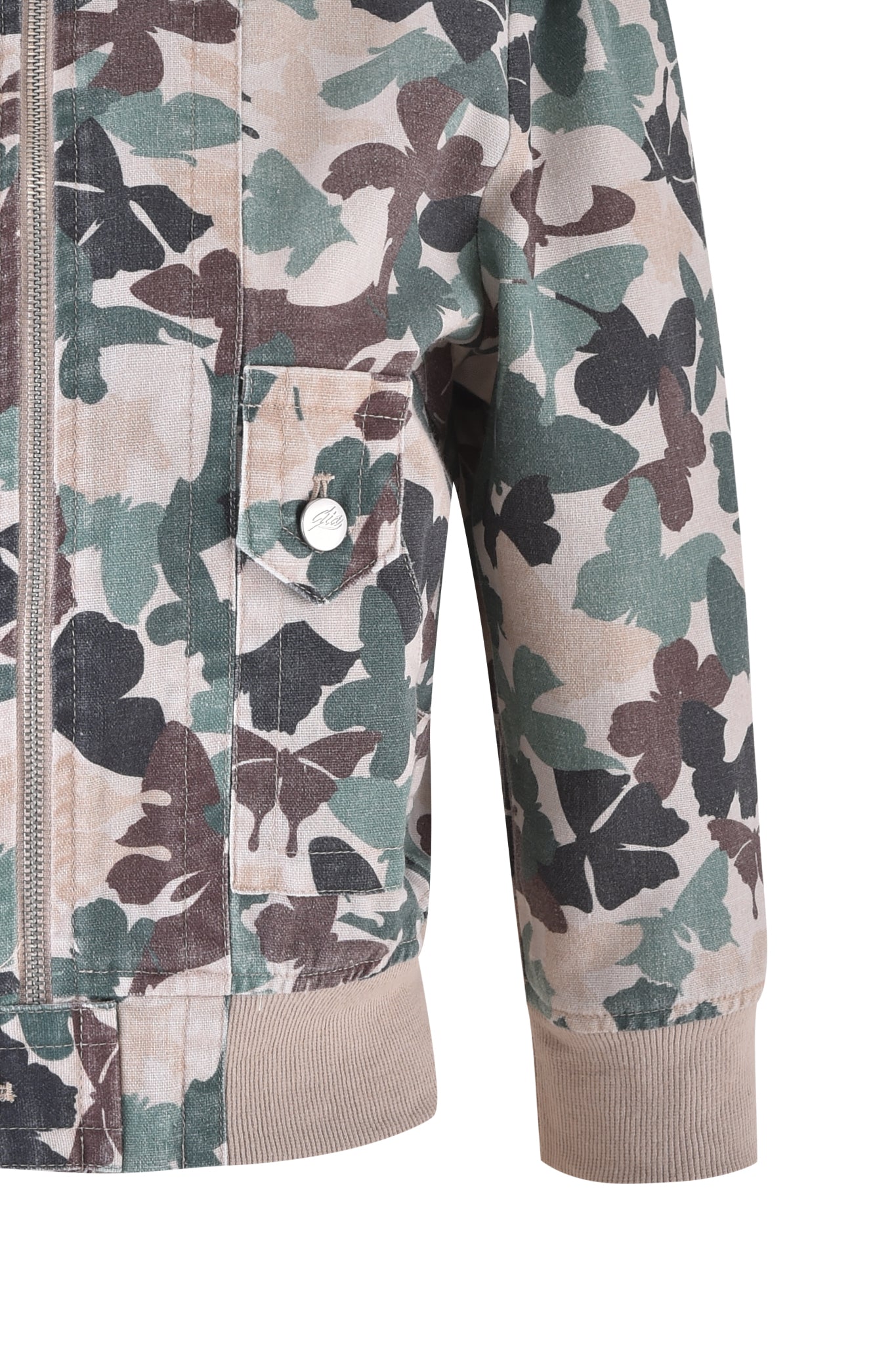 Close-up of the EFFIE JACKET - FLUTTER CAMO by I.AM.GIA: a cropped cargo style with butterfly camo print featuring green, brown, and beige abstract shapes, ribbed cuffs, a flap pocket with button on the sleeve, and a visible front zipper.