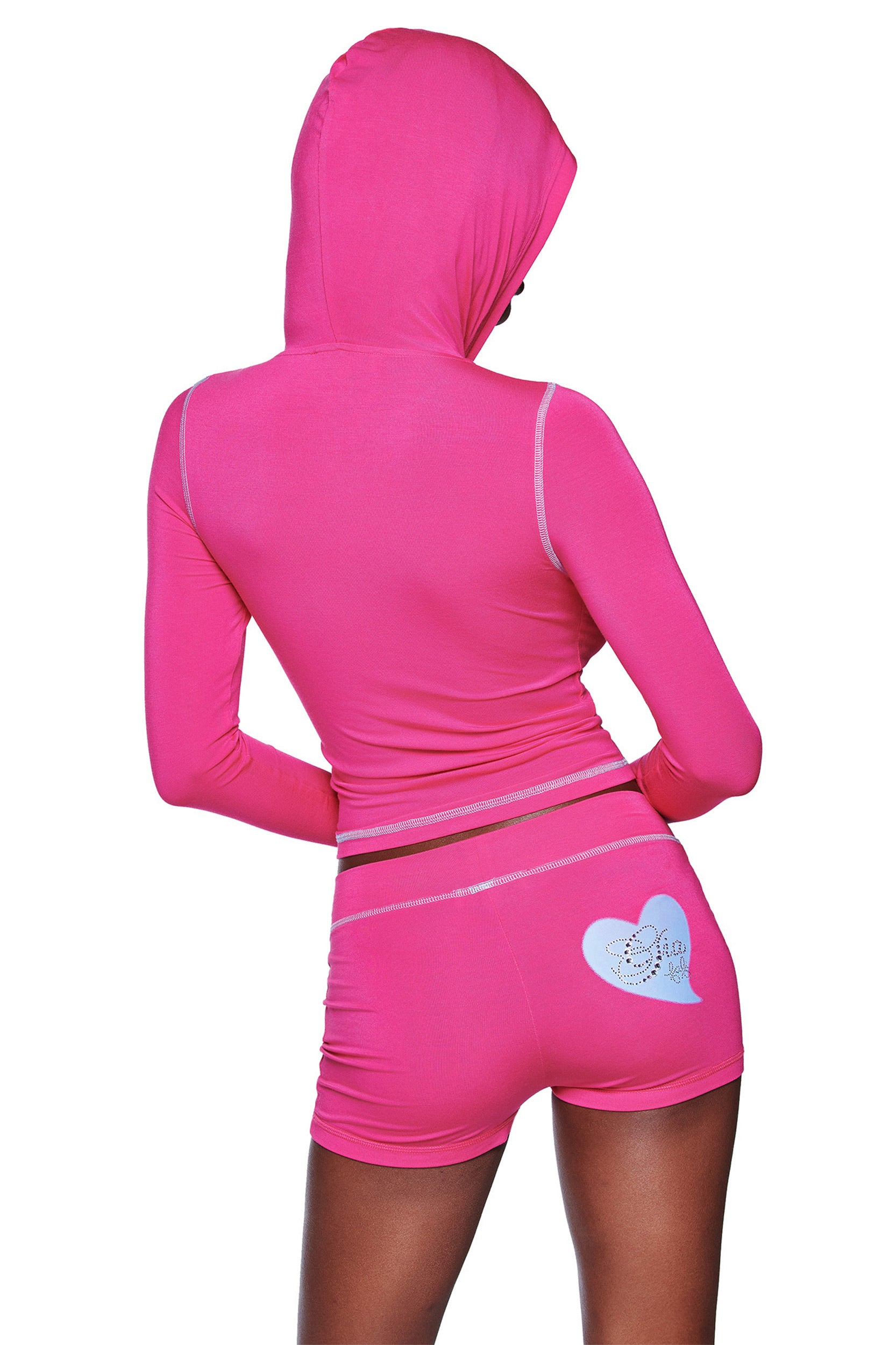 A person wearing a hot pink I.AM.GIA hooded long-sleeve top and FAFI BLARE SHORT, shown from the back. The shorts feature a heart graphic and “Doll” printed on the right side.