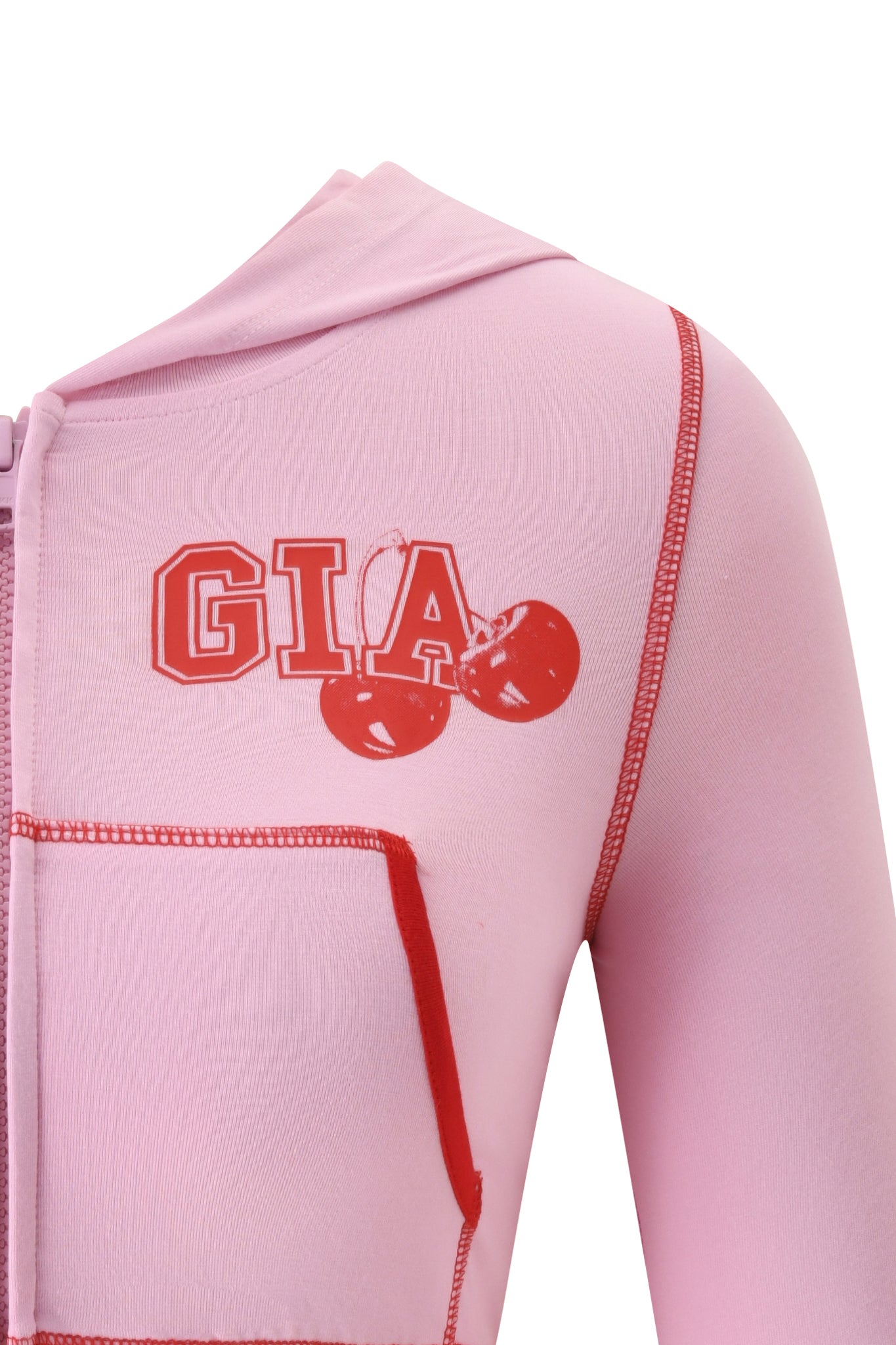 Close-up of the BLARE CROPPED HOODIE in baby pink by I.AM.GIA, featuring red stitching, a red cherry graphic, and "GIA" lettering on the chest.