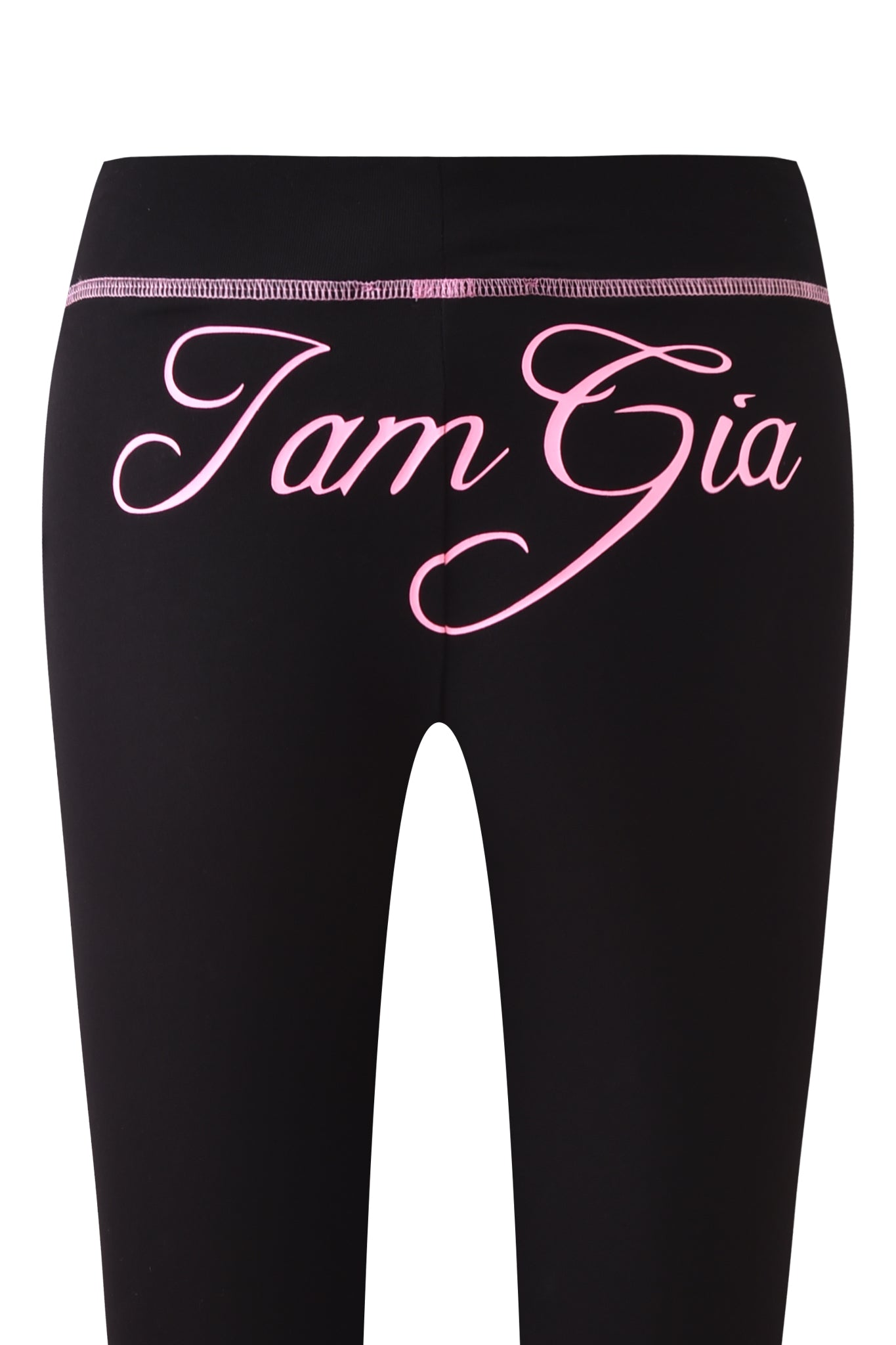 The BLARE CAPRI - BLACK by I.AM.GIA features pink cursive logo lettering across the back and pink stitching along the waistband.