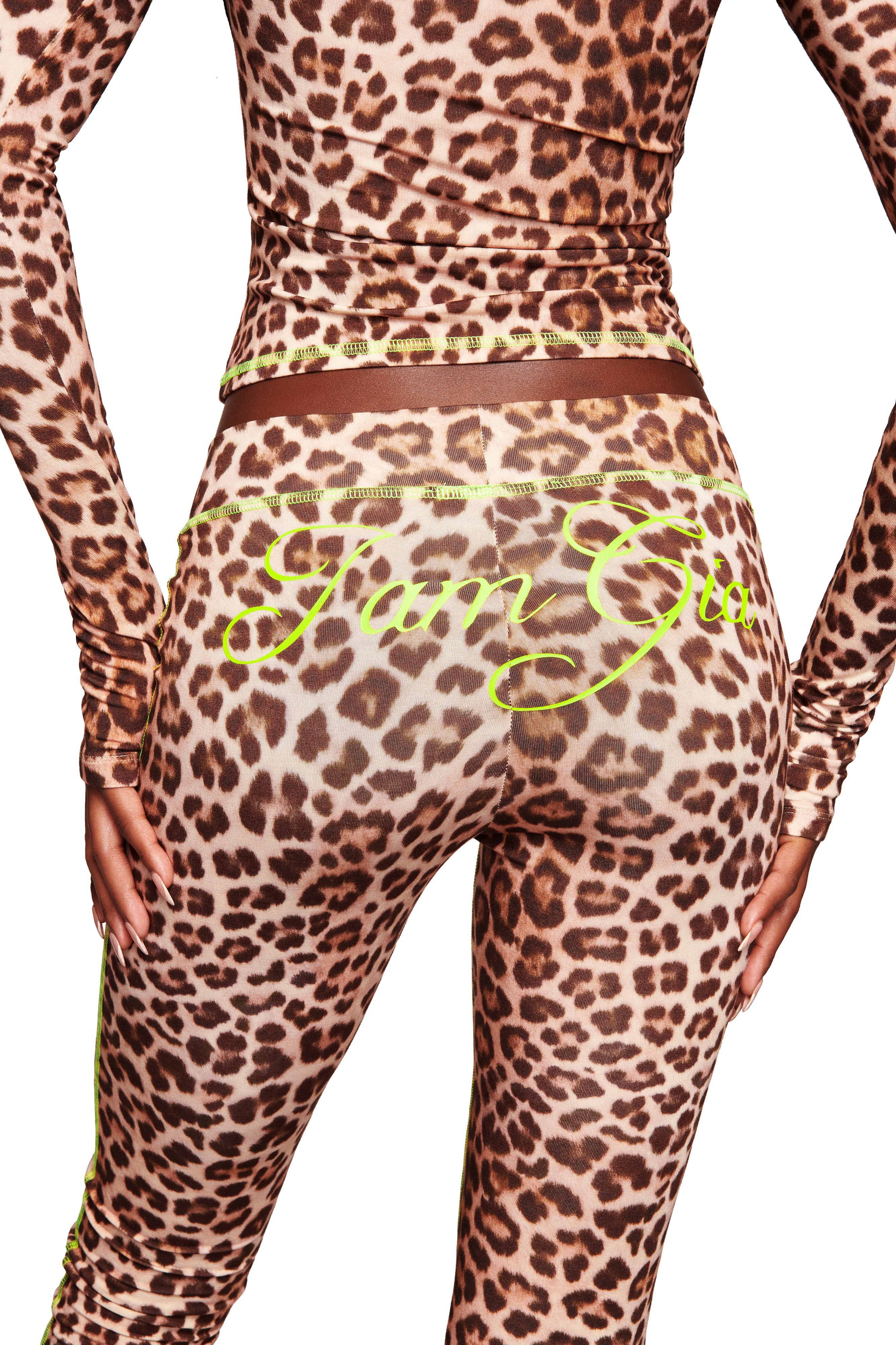 A person wears the I.AM.GIA BLARE CAPRI - LEOPARD with a matching long-sleeve top; neon yellow "Fun Girl" script is printed across the back of the leggings.