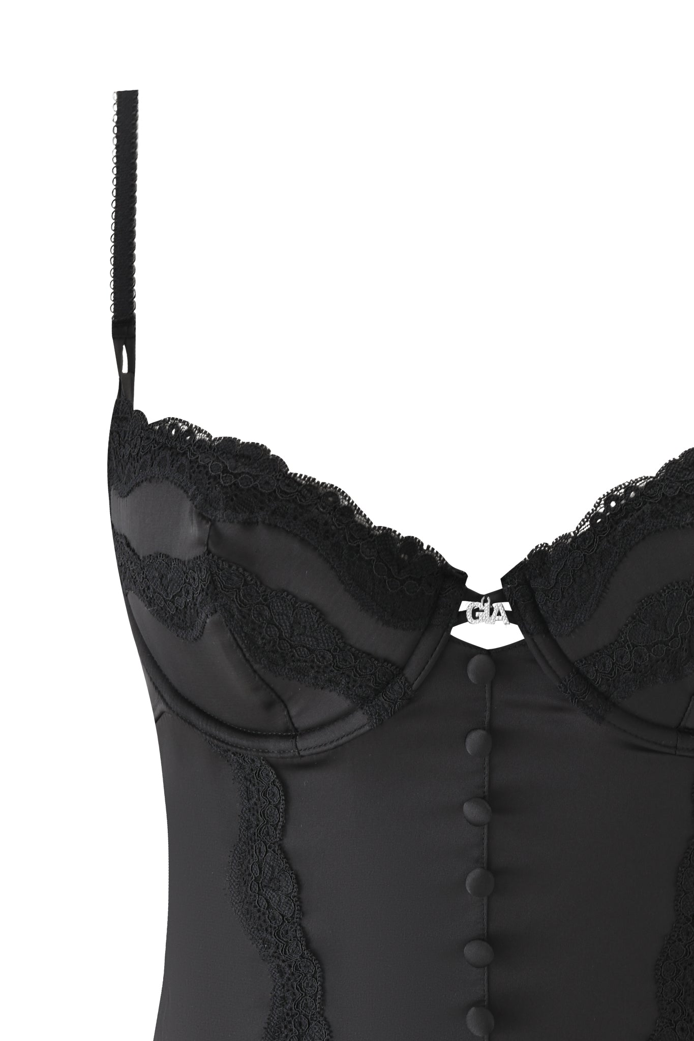 Close-up of the ASHLING BUSTIER - BLACK by I.AM.GIA, featuring black satin, scalloped lace cups, fabric-covered buttons down the center, adjustable satin straps, and a silver neckline charm.