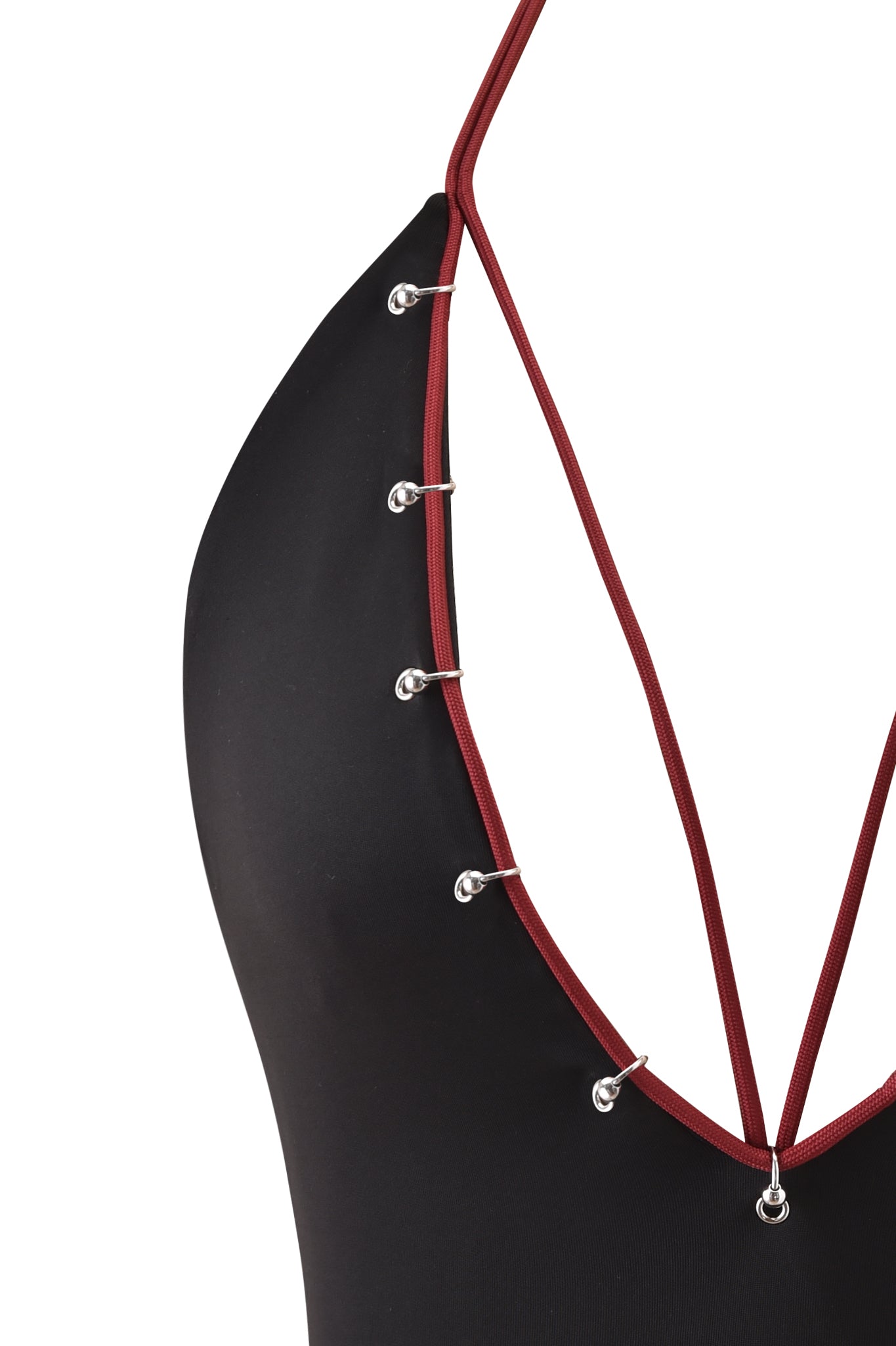 Close-up of the ONYX TOP - BLACK by I.AM.GIA, a black halter with maroon straps and silver rings, featuring a plunging neckline and bodycon fit for a modern, stylish look.