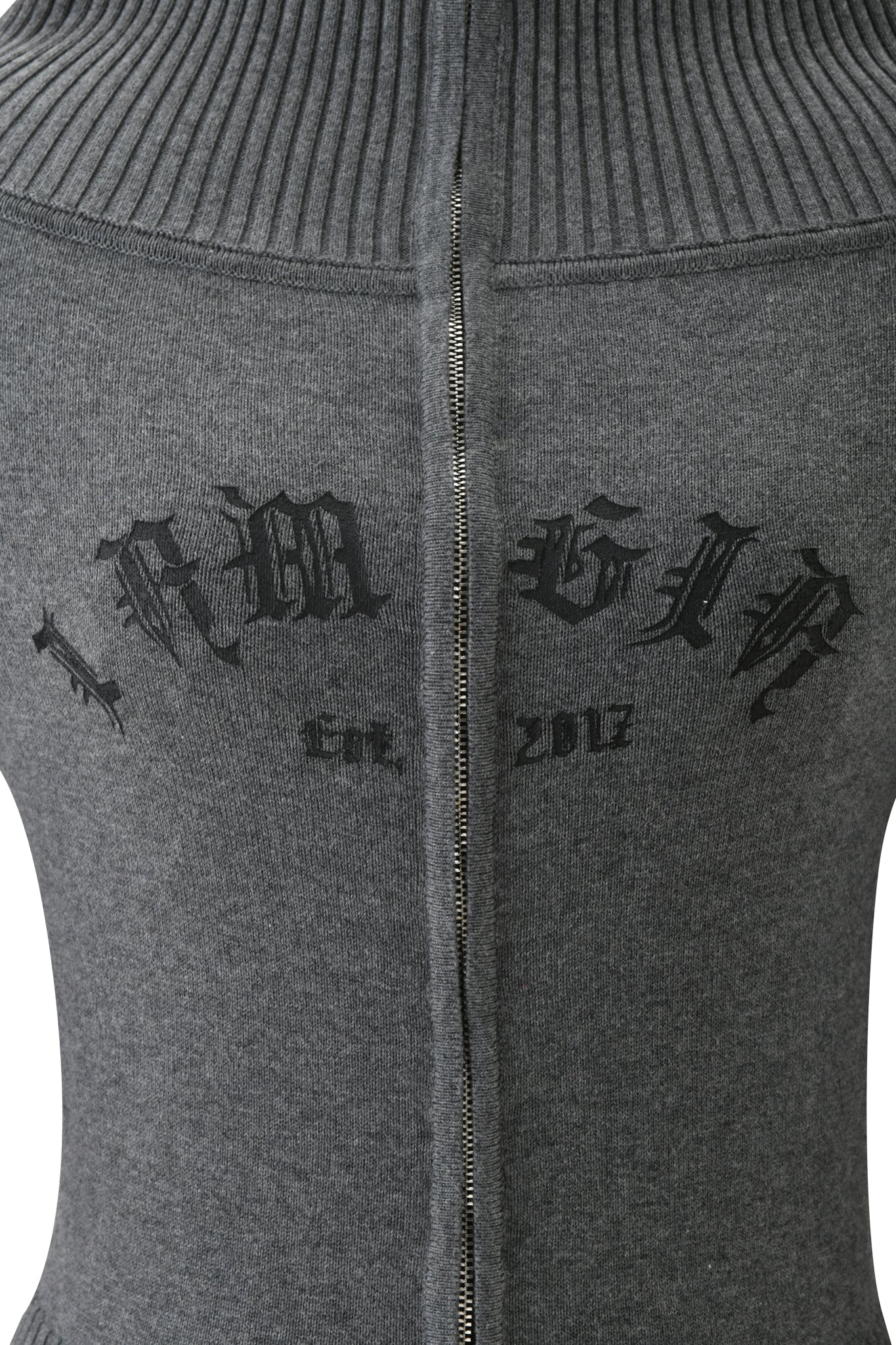 Close-up of the ZION CARDIGAN - GREY by I.AM.GIA, an off-shoulder sweater with a central zipper and “IAMGIA Est. 2017” in black gothic text across the back.