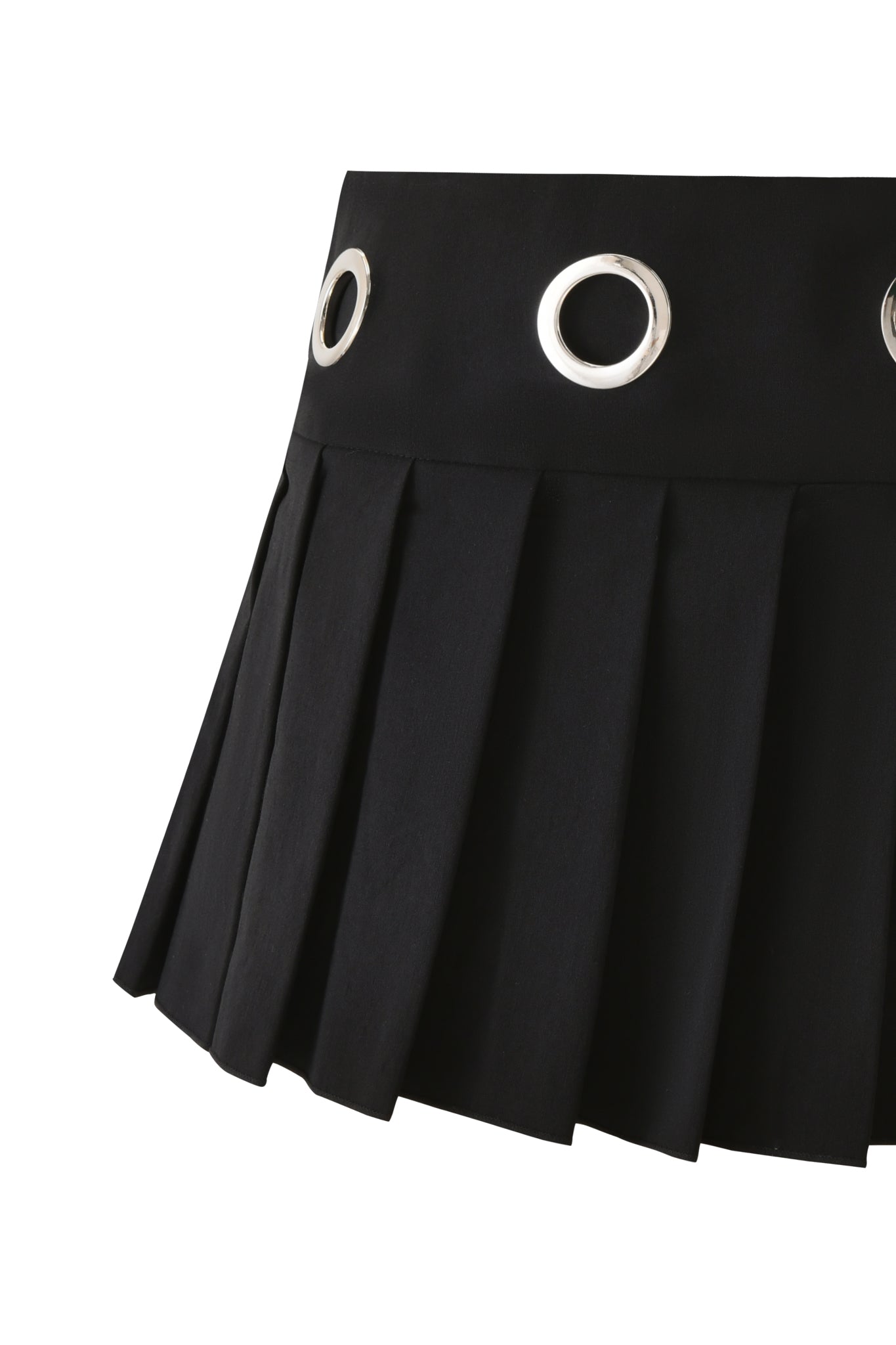 Close-up of the I.AM.GIA JAYMES SKORT in black, featuring pleated skirt styling and large silver grommets on the waistband, shown against a white background.