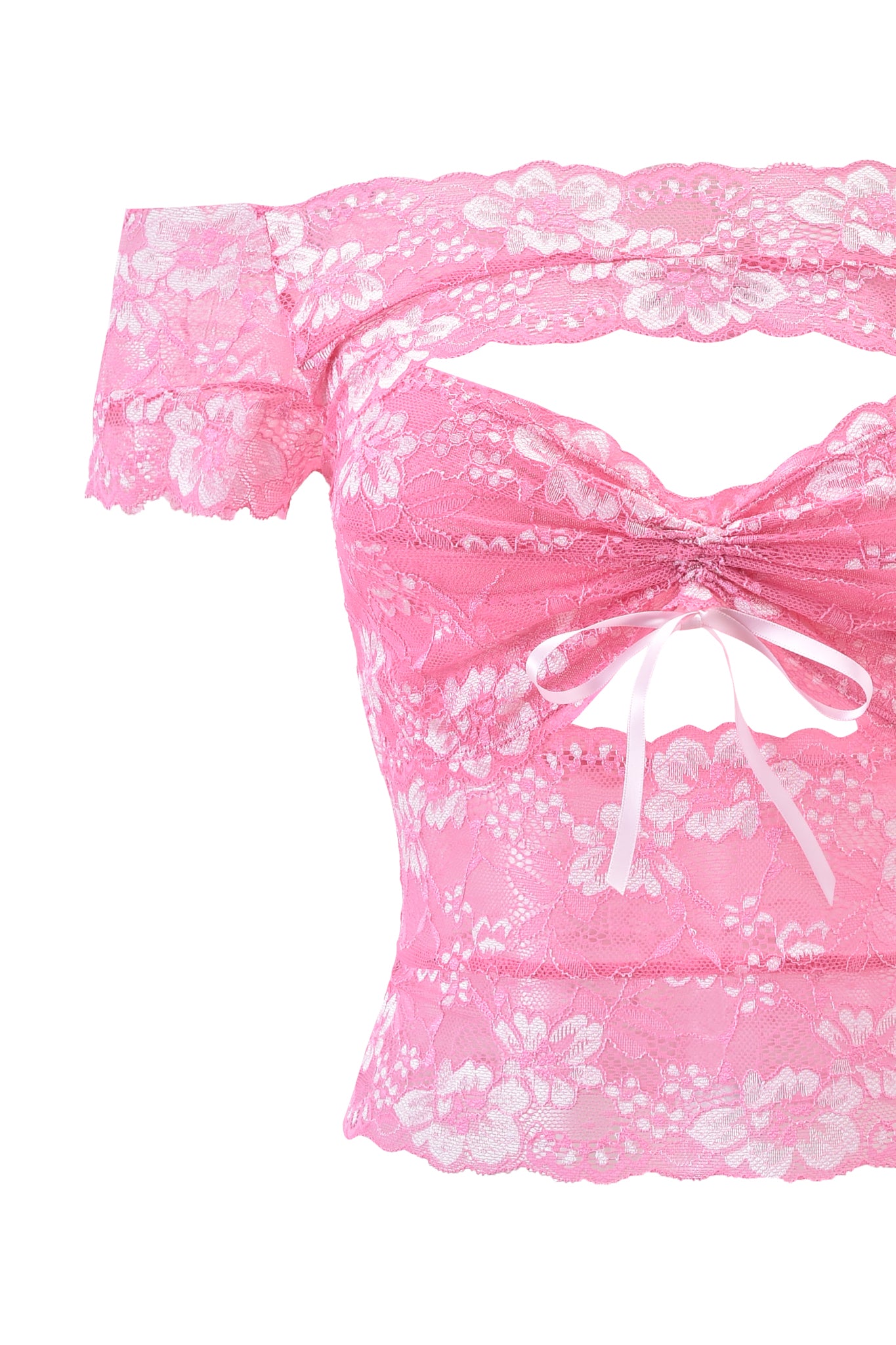 The CRYSTAL TOP - PINK by I.AM.GIA is a pink stretch lace off-shoulder crop top with floral patterns, a cut-out below the neckline, and a white ribbon bow at the center front.