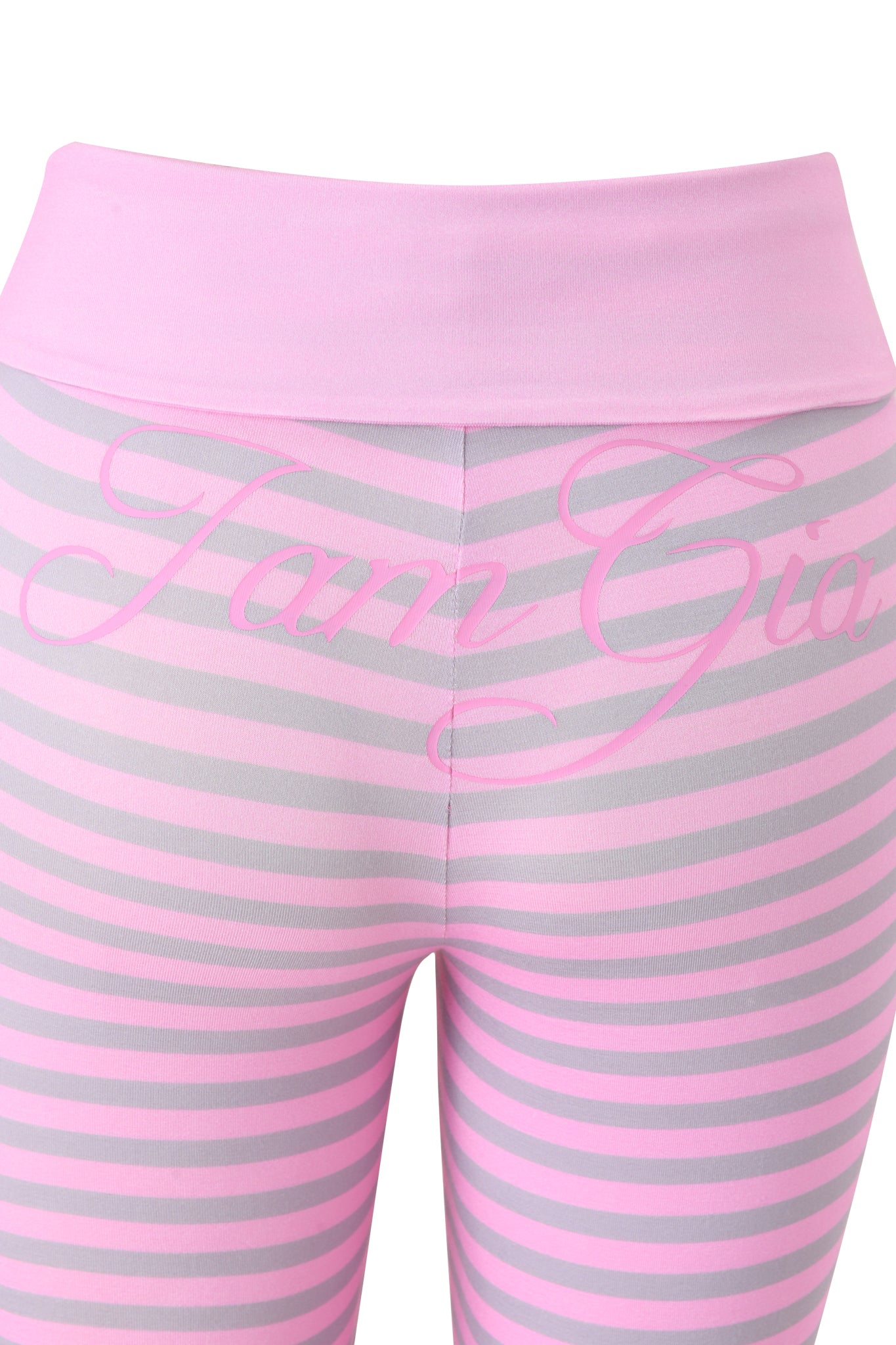 Close-up of the BLARE FOLDOVER TRACKPANT - LIGHT PINK STRIPE by I.AM.GIA, featuring pink and light gray stripes, a foldover waistband, and "I.AM.GIA" printed in pink across the back, inspired by the original Blare Trackpant style.