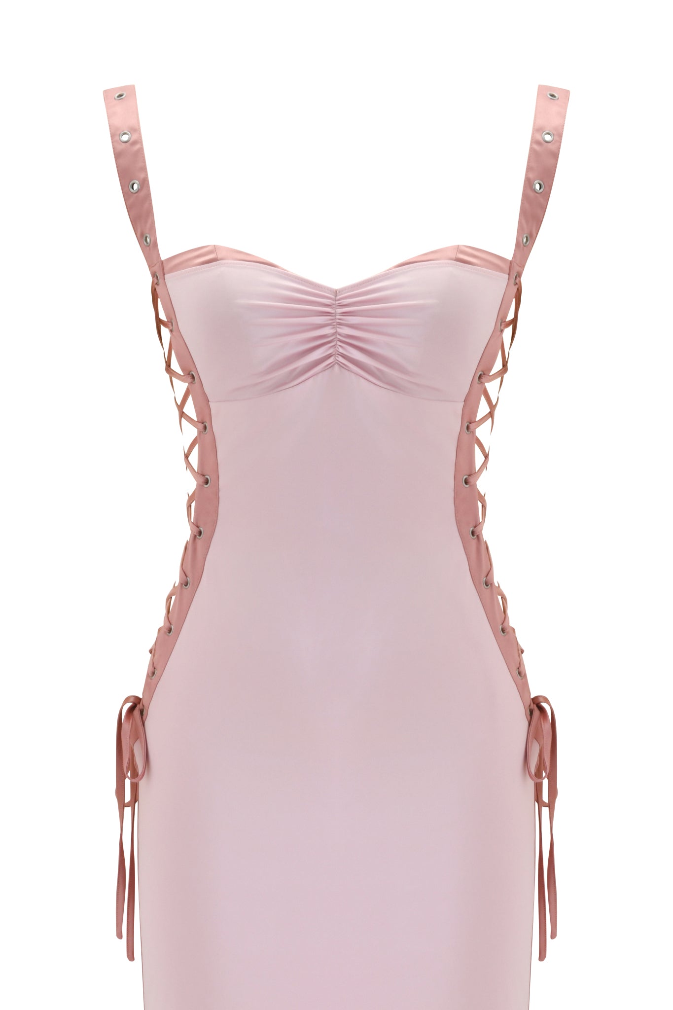 The ASHLEE MAXI DRESS by I.AM.GIA features a light pink stretch satin fabric, sweetheart neckline, ruched bust, lace-up sides with silver eyelets, ribbon ties at the hips, and is photographed against a plain white background.