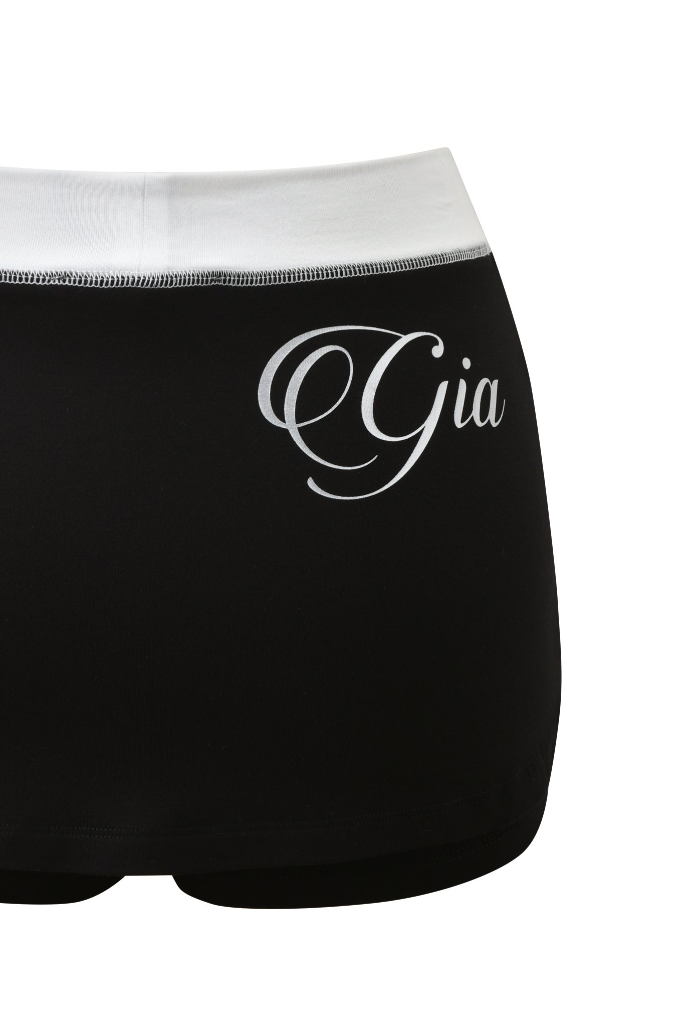 The BLARE MICRO SKORT by I.AM.GIA features a black and white design with a mid rise waist and "Gia" written in cursive on the back.