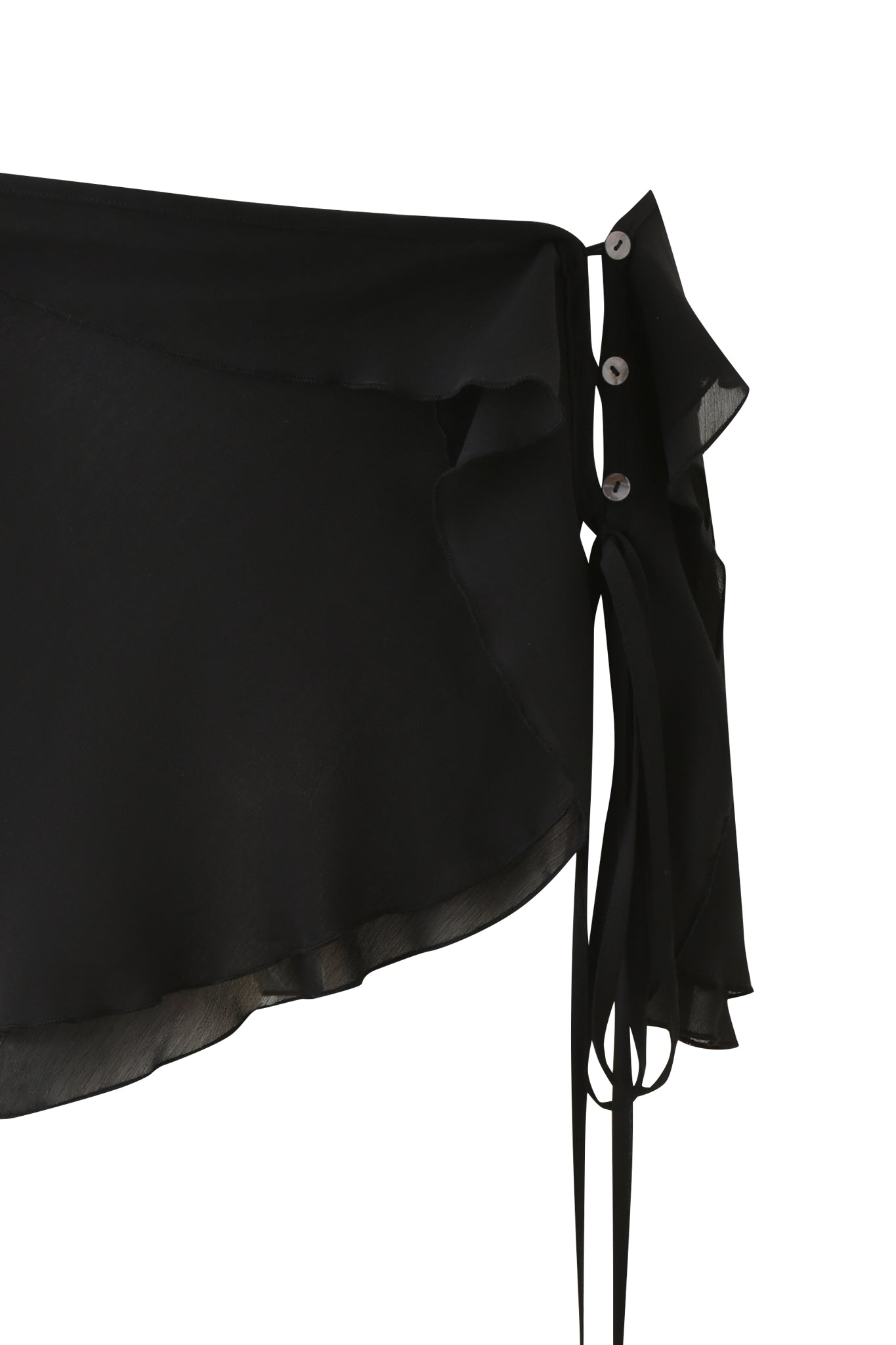 Close-up of the I.AM.GIA PORTIA RUFFLE MINI SKIRT - BLACK, a semi-sheer mini with asymmetrical ruffled edges, side tie detail, and three silver grommets, shown against a plain white background.