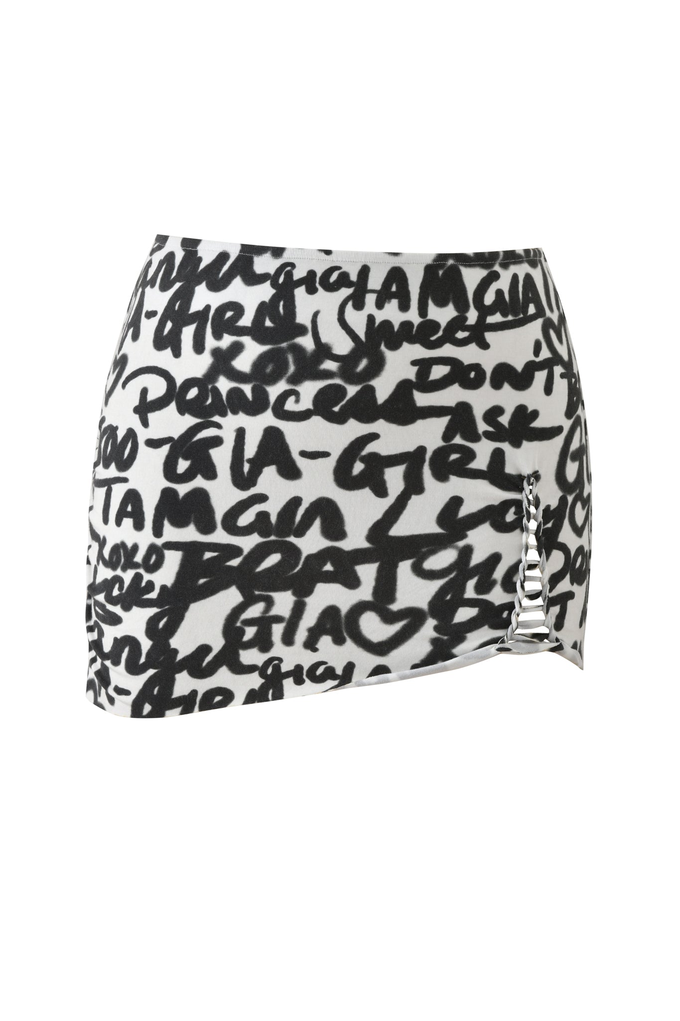 The HONEY MACRAME MINI SKIRT - WRITING ON THE WALL by I.AM.GIA is a white graffiti-print mini skirt with bold black text and a side cut-out featuring horizontal white laces for an edgy, bodycon style.