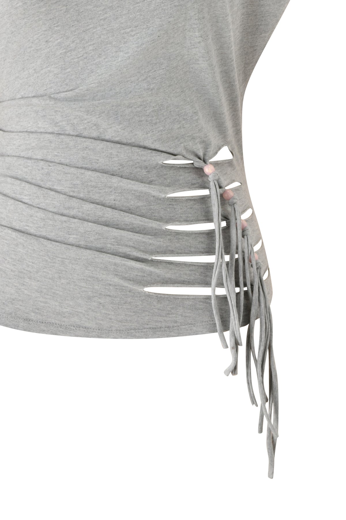 A close-up of the BEX OFF SHOULDER TOP in grey by I.AM.GIA, featuring gray fabric with horizontal slits held together by tied strips that create a fringe effect along the side. The background is white.