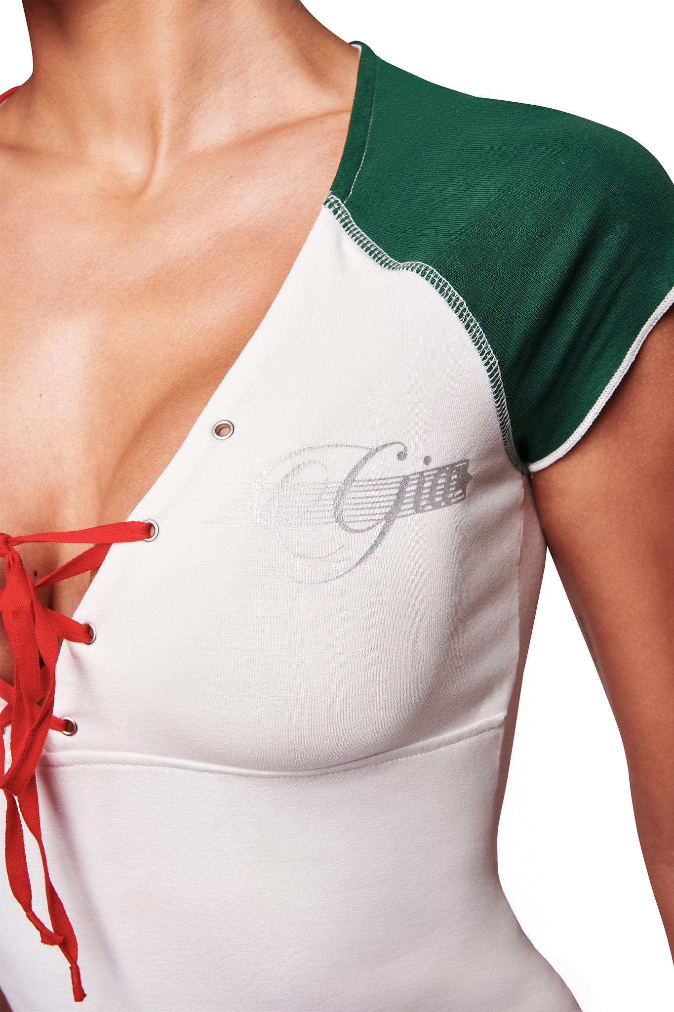 A close-up of a person wearing the I.AM.GIA NOVIA LACE-UP T-SHIRT AND HEADBAND in white, featuring green and red lace-up details, a “Giro” print, and a stylized graphic on the chest against a white background.