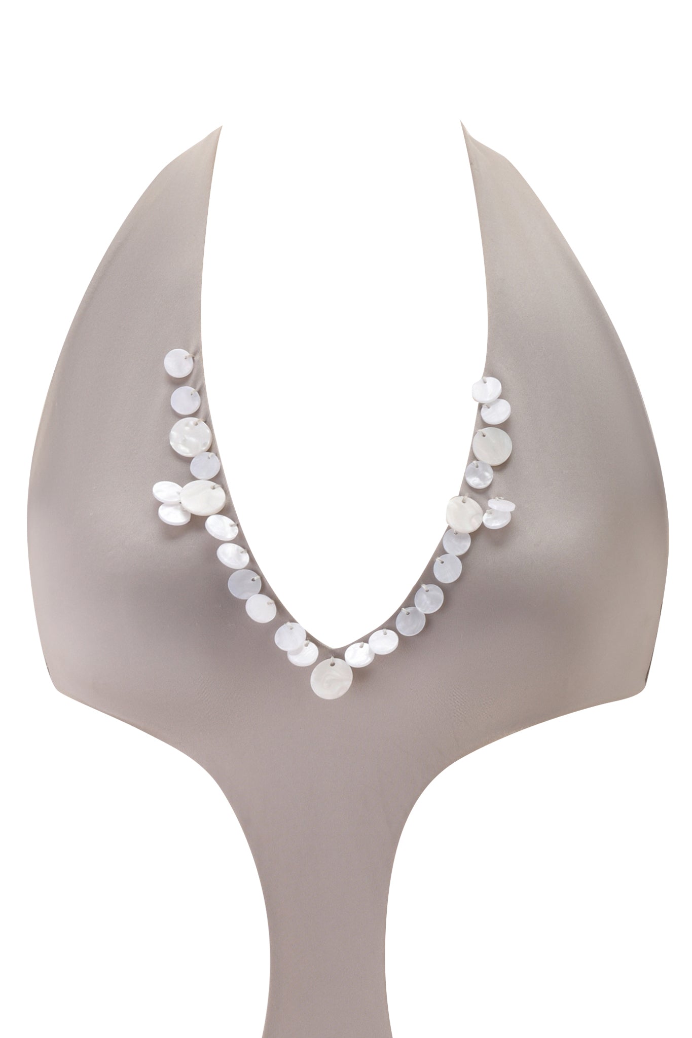 A sculptural, abstract mannequin showcases the I.AM.GIA GENE EMBELLISHED ONE PIECE SWIMSUIT - PEARLESCENT, featuring flat, round white beads arranged asymmetrically along a deep V-neckline against a plain white background.