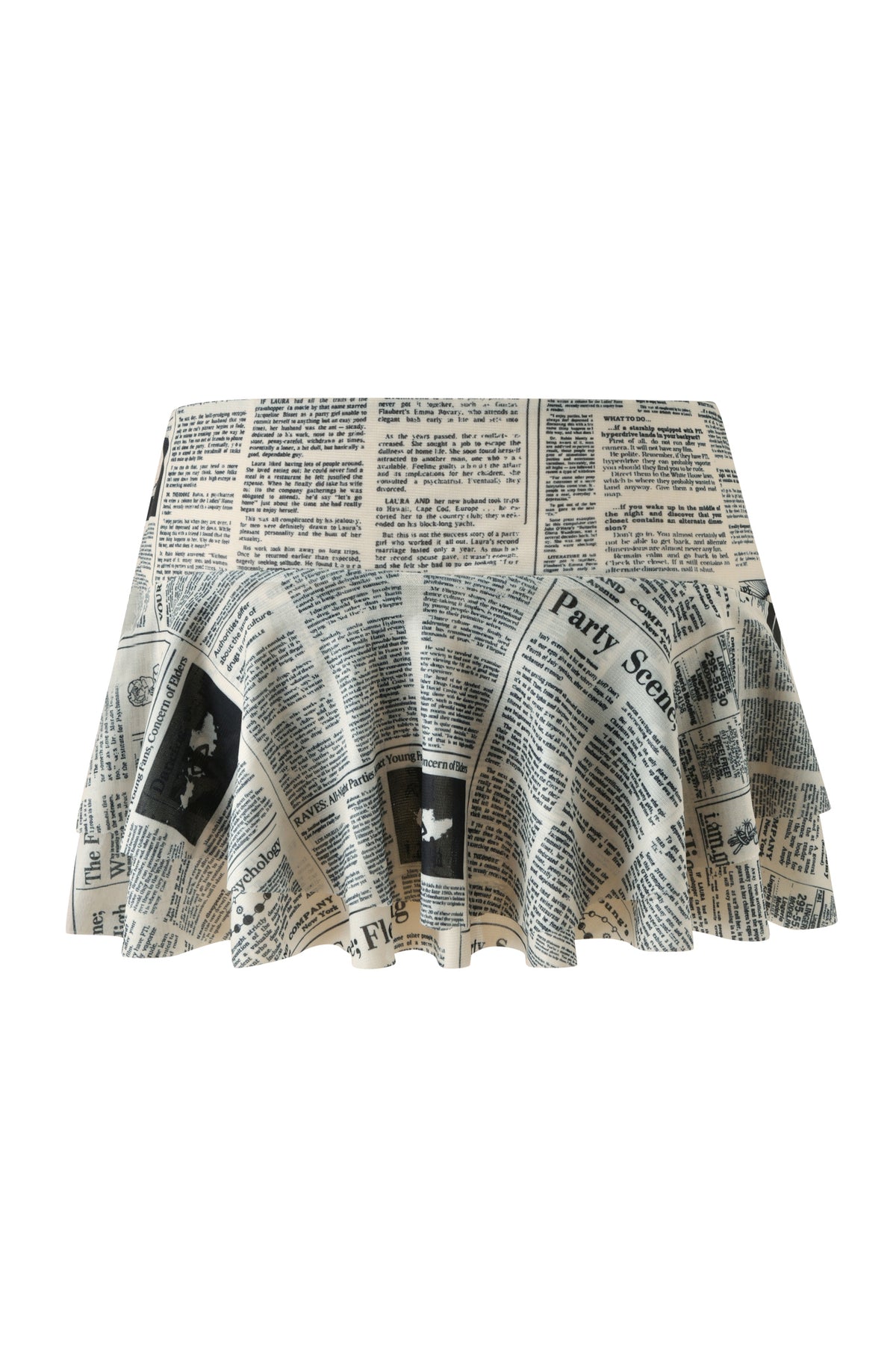 The SORA MINI SKIRT - LEFT ON READ by I.AM.GIA is a mesh ruffled mini skirt with a black-and-white newspaper print, showcasing assorted articles and headlines. Its pleated fabric flares gently, creating playful movement and making it a standout statement piece.
