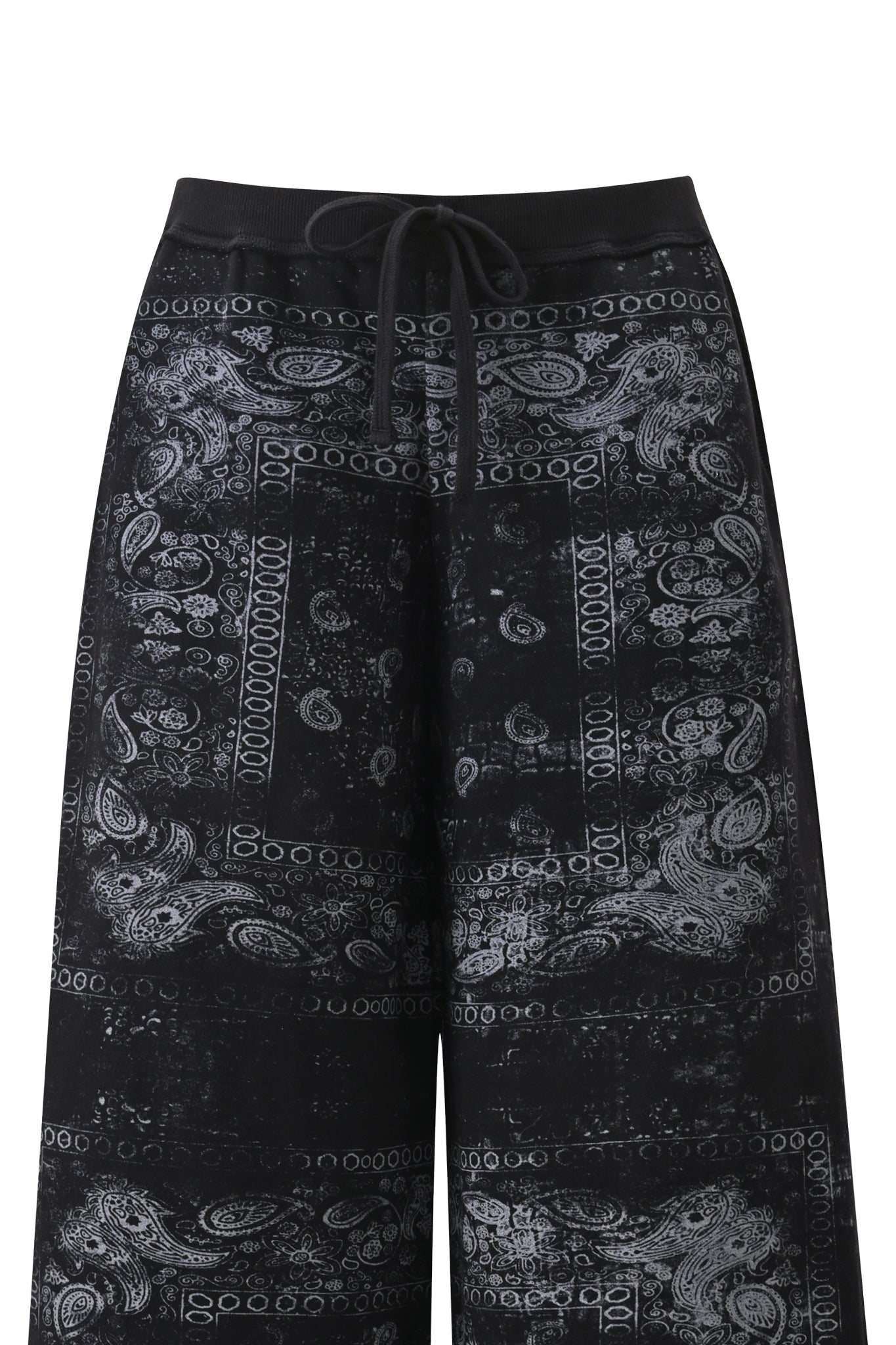 The I.AM.GIA T-REX TRACKPANT in Black Bandana showcases a wide-leg, relaxed-fit silhouette with a bold black bandana print featuring white paisley and geometric patterns. Designed with visible front pockets, only the upper portion of these street-style pants is displayed against a white background.