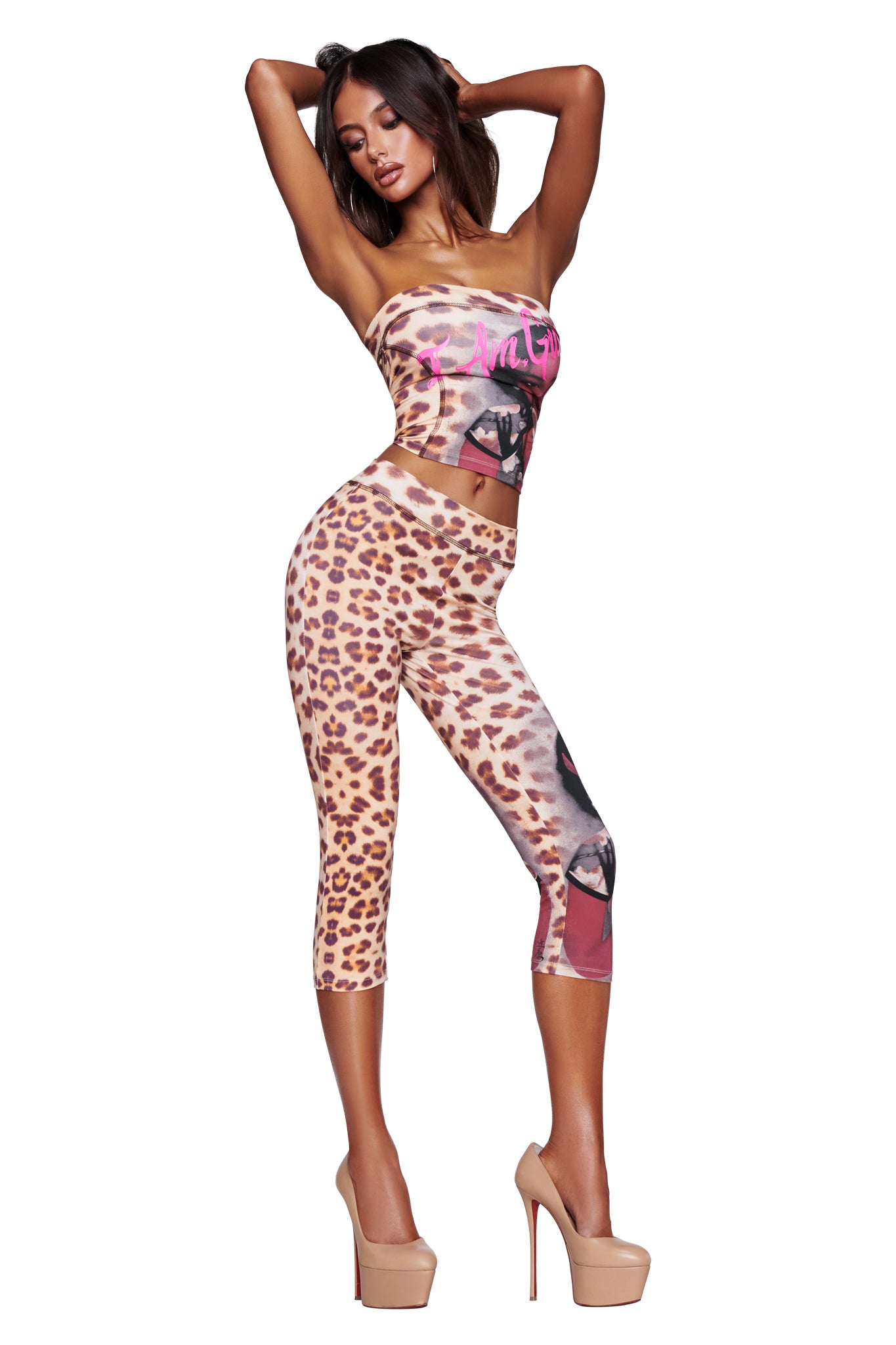A woman poses in high heels, wearing the I.AM.GIA T-REX BLARE BOOB TUBE - WILD CARD and matching graphic-accented leggings, set against a plain white background.
