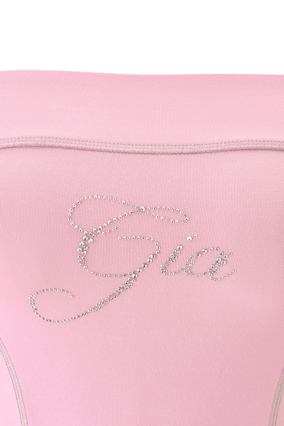 Close-up of the BLARE DIAMONTE BOOB TUBE in baby pink by I.AM.GIA, showcasing the word “Gia” written in cursive with a sparkling rhinestone logo—perfect for a chic, bodycon crop top look.