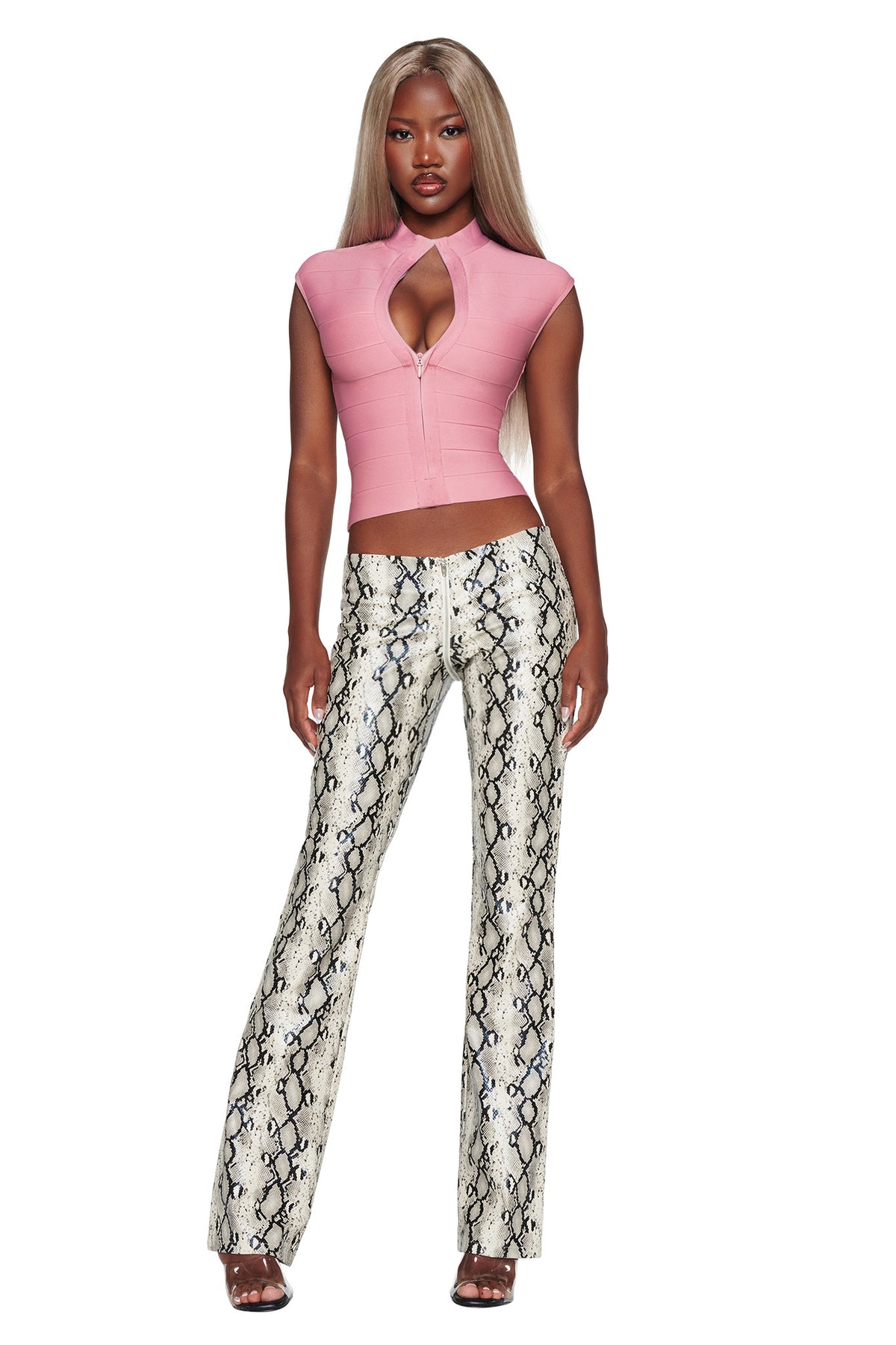 A woman with long, straight hair wears a pink fitted top with a keyhole cutout and I.AM.GIA HENDRIX 2.0 Pant in Cream Snake, standing against a white background.