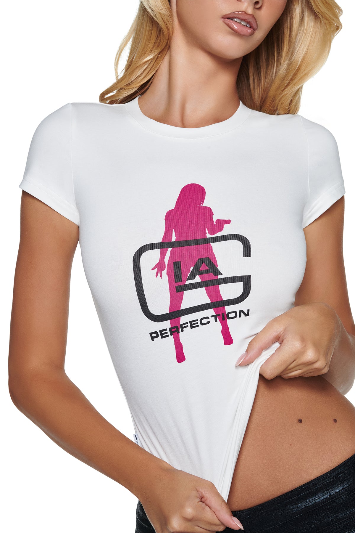 Person wearing a white YVL T-SHIRT - WHITE GIA featuring a pink silhouette, black “IA” lettering, and the word “PERFECTION” underneath.