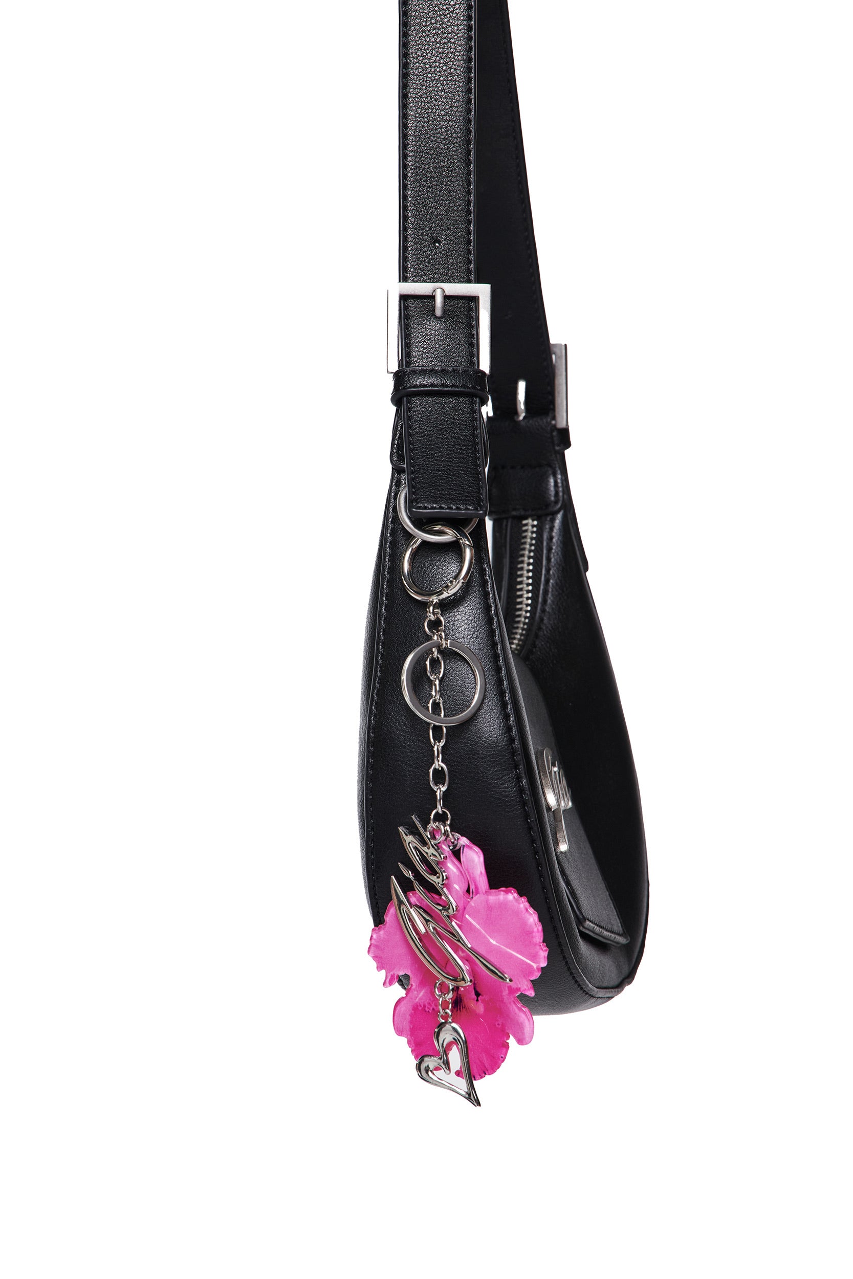 A black leather handbag with a silver buckle features the I.AM.GIA ORCHID KEYCHAIN - NEON PINK, adorned with flower-shaped charms and a silver heart, hanging from the strap.