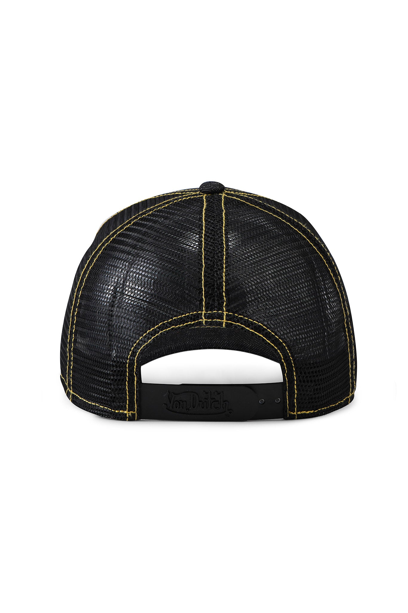 The image shows the back of the I.AM.GIA X VON DUTCH TRUCKER HAT in indigo denim, featuring black mesh, yellow stitching, an adjustable closure, and "Von Dutch" embossed on the strap for signature style.